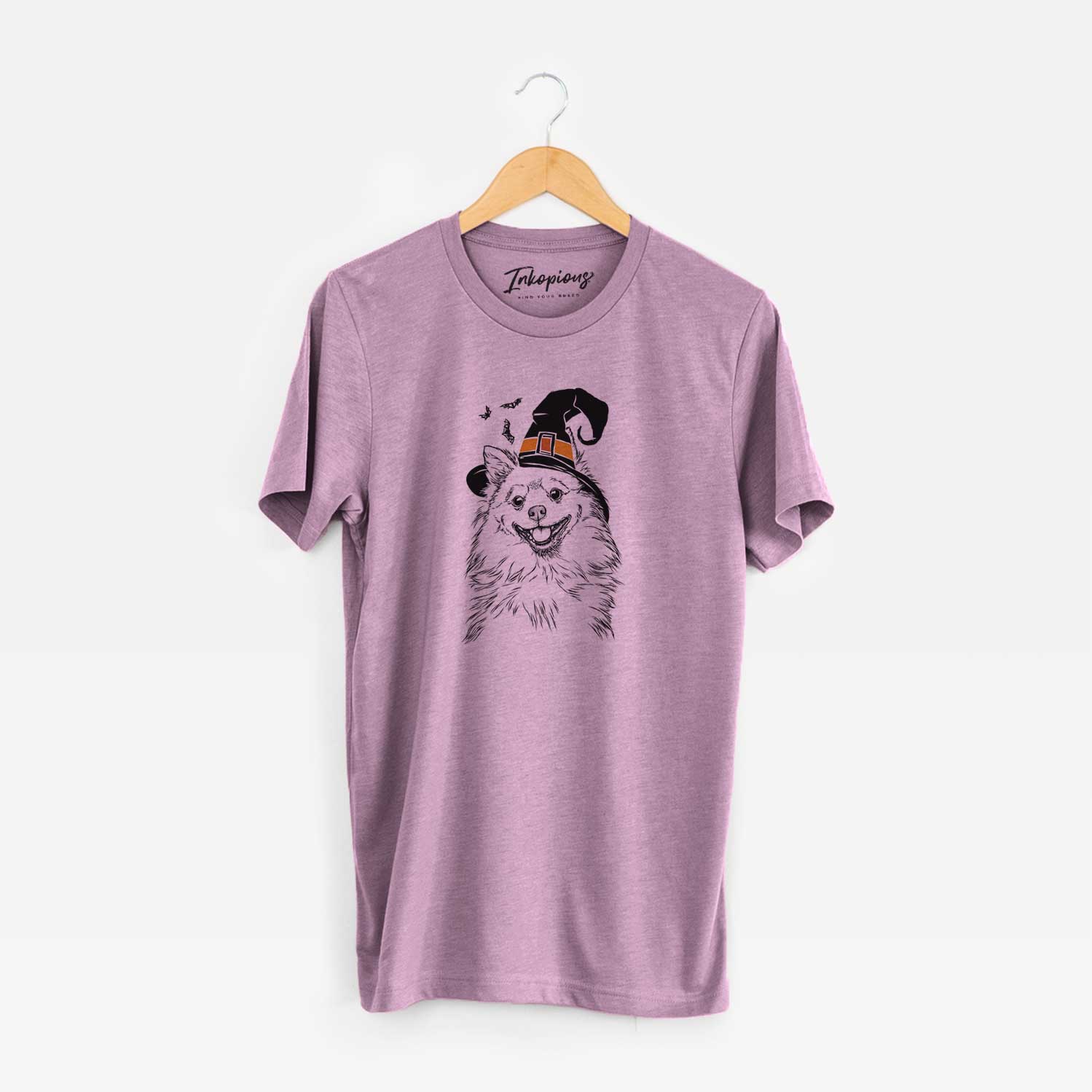 Hand-drawn sketch of Fibi the Spitz wearing a witch hat on an Orchid Unisex crewneck