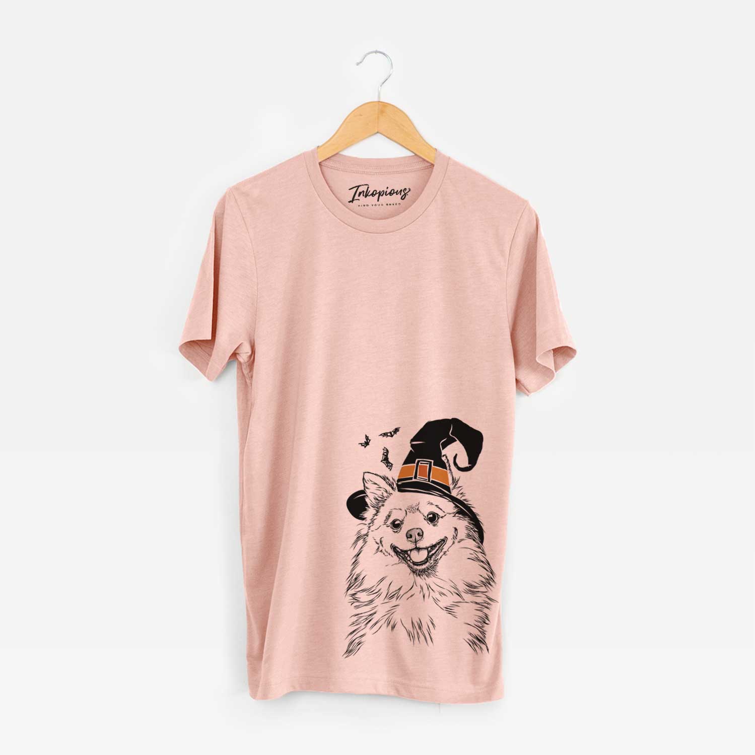 Hand-drawn sketch of Fibi the Spitz wearing a witch hat on a Peach Unisex crewneck