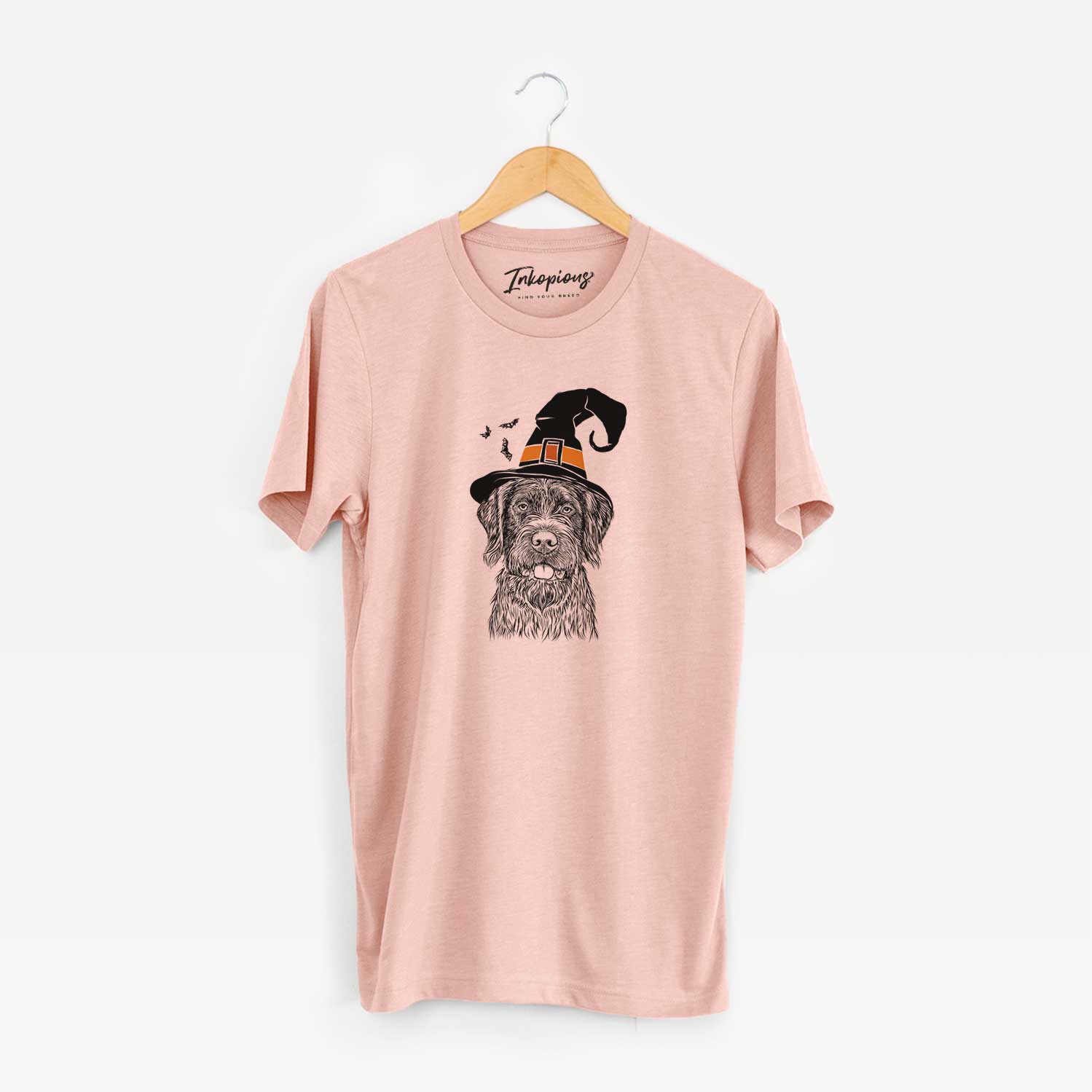 Hand-drawn sketch of Fletcher the Wirehaired Pointing Griffon wearing a witch hat on a Peach Unisex crewneck