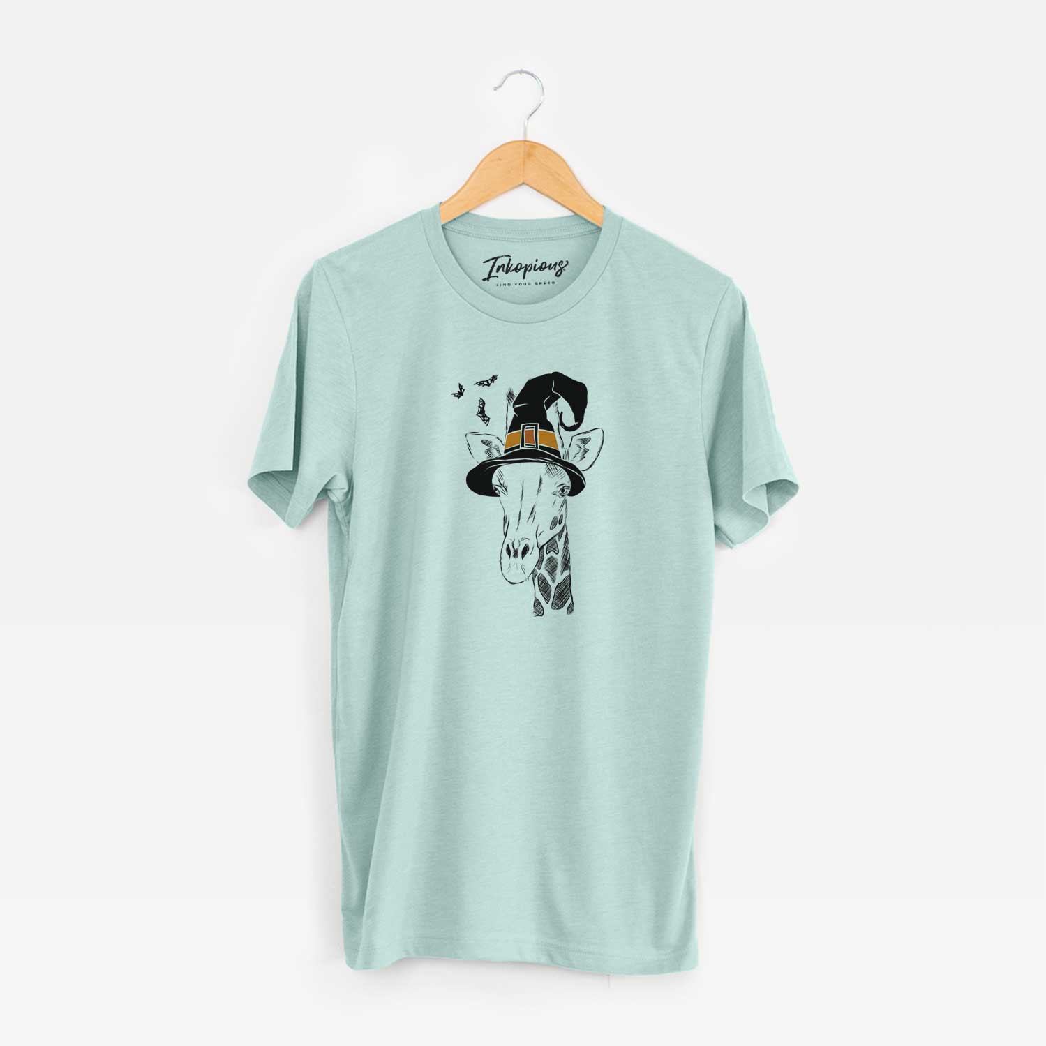 Hand-drawn sketch of Geoffrey the Giraffe wearing a witch hat on a Heather Sage Unisex crewneck