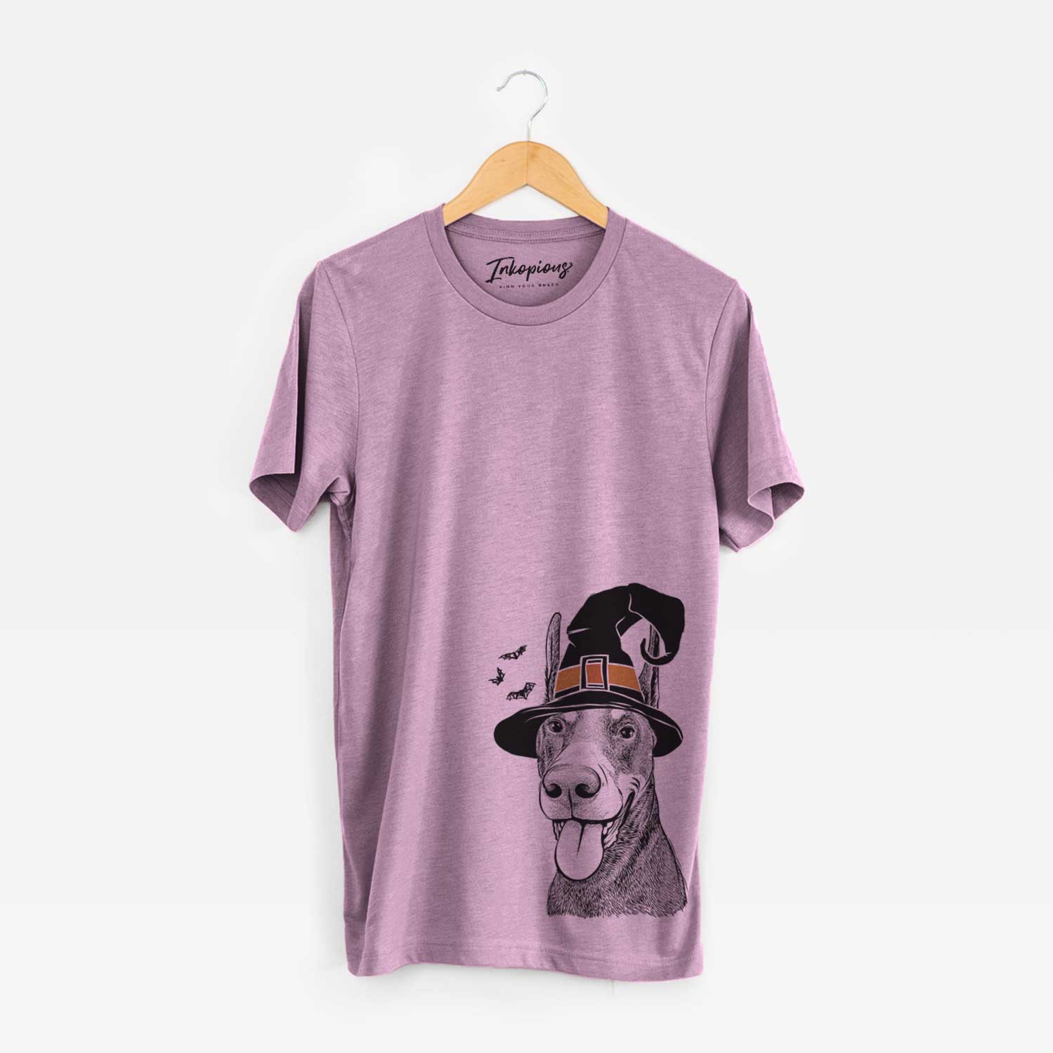 Hand-drawn sketch of Happy Sunny the Doberman Pinscher wearing a witch hat on an Orchid Unisex crewneck