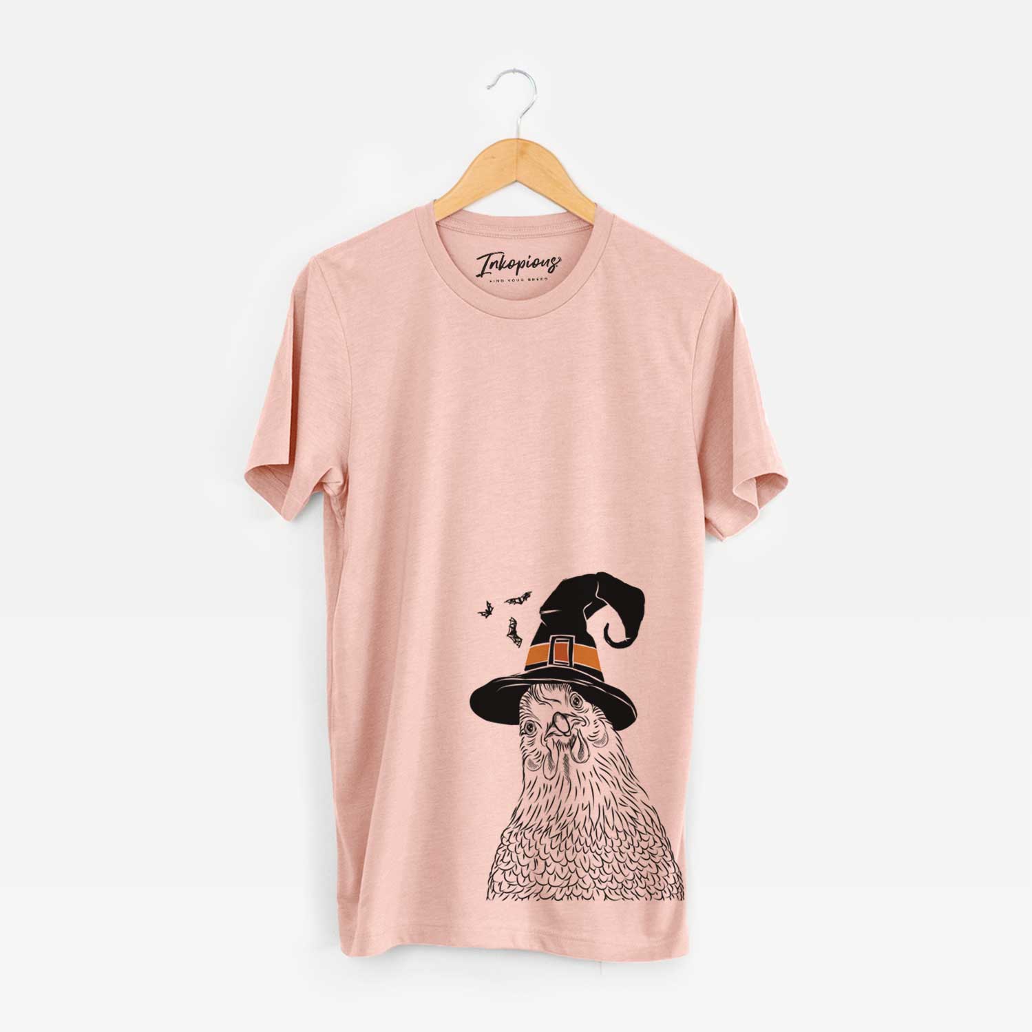 Hand-drawn sketch of Henrietta the Chicken wearing a witch hat on a Peach Unisex crewneck