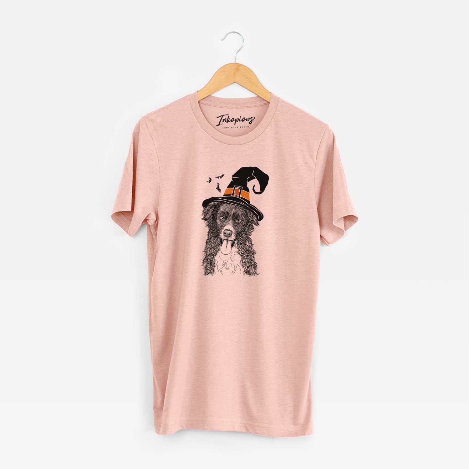 Hand-drawn sketch of Indi the Border Collie wearing a witch hat on a Peach Unisex crewneck