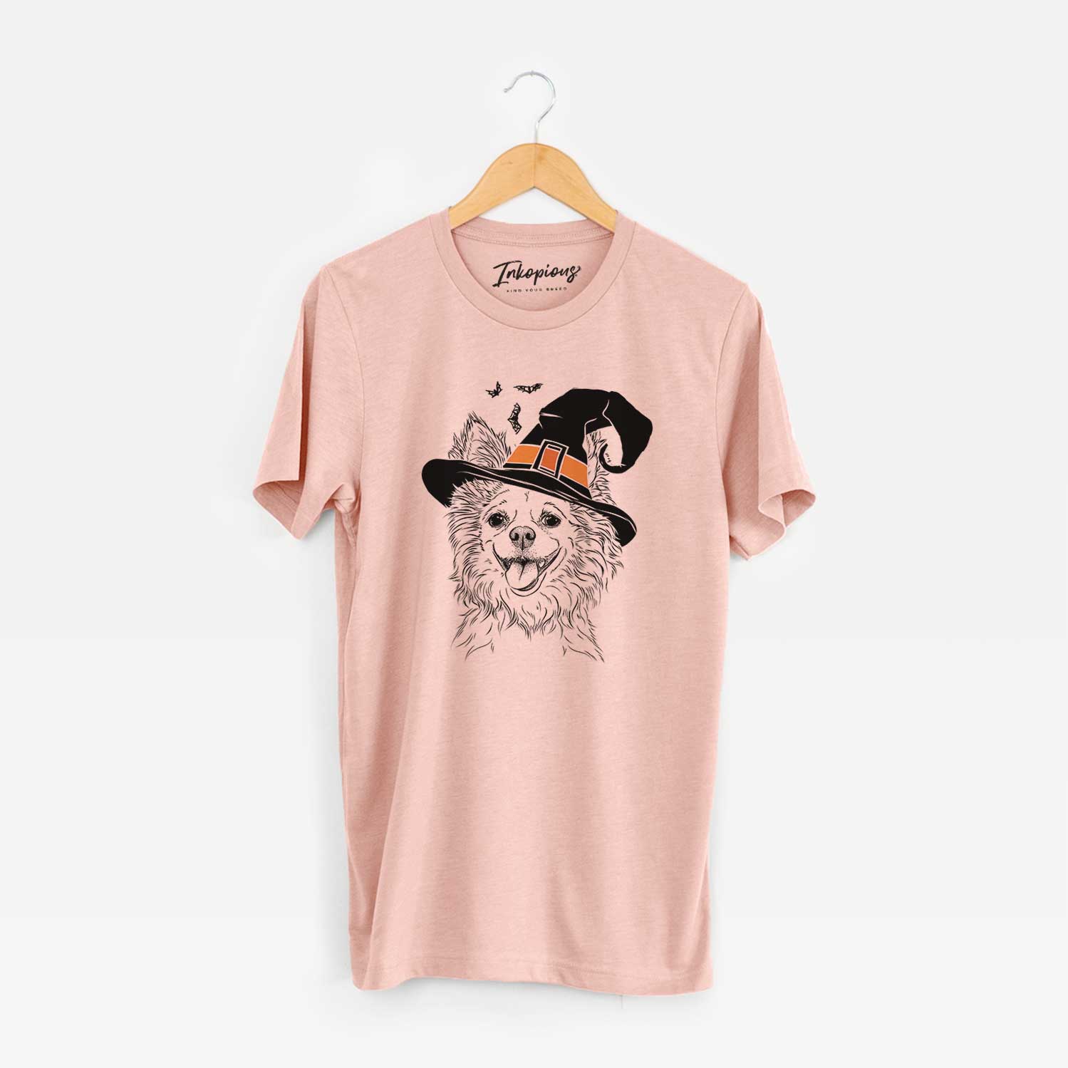 Hand-drawn sketch of Jasper the Pomchi wearing a witch hat on a Peach Unisex crewneck