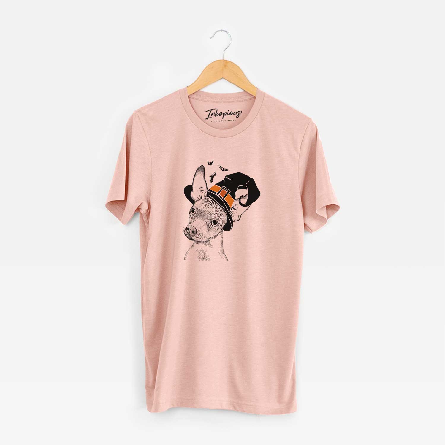 Hand-drawn sketch of Kahlo the Xoloitzcuintli wearing a witch hat on a Peach Unisex crewneck