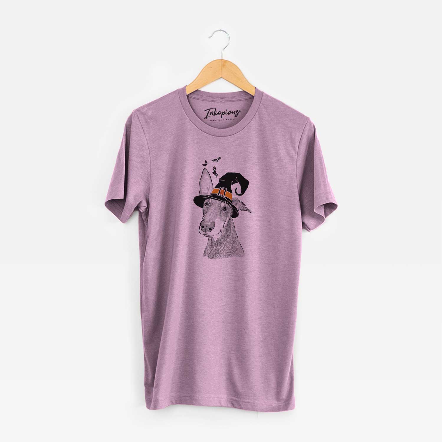 Hand-drawn sketch of Kain the Doberman Pinscher wearing a witch hat on an Orchid Unisex crewneck