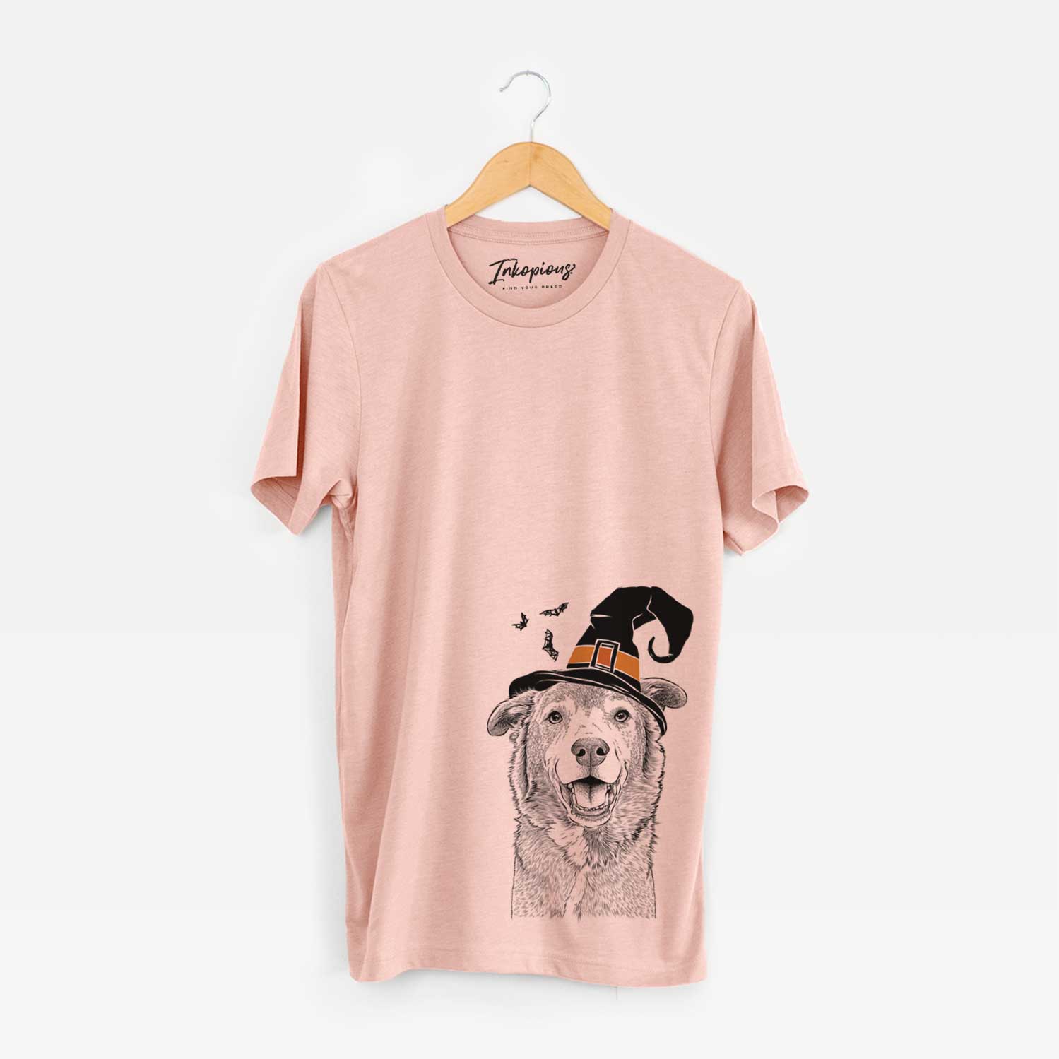 Hand-drawn sketch of Logan the Rescue Mutt wearing a witch hat on a Peach Unisex crewneck
