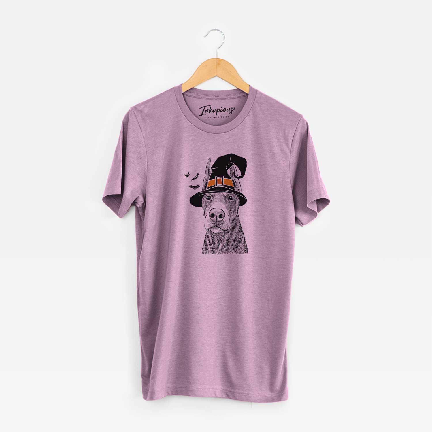Hand-drawn sketch of Luna the Doberman Pinscher wearing a witch hat on an Orchid Unisex crewneck
