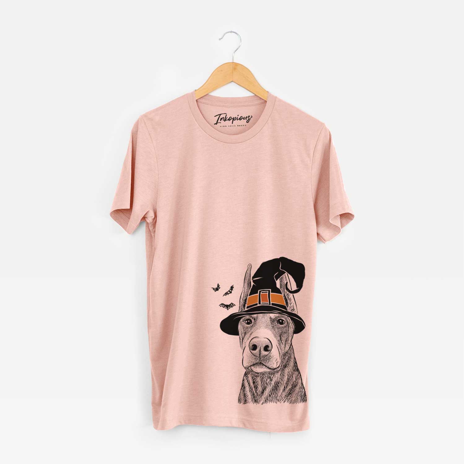 Hand-drawn sketch of Luna the Doberman Pinscher wearing a witch hat on a Peach Unisex crewneck