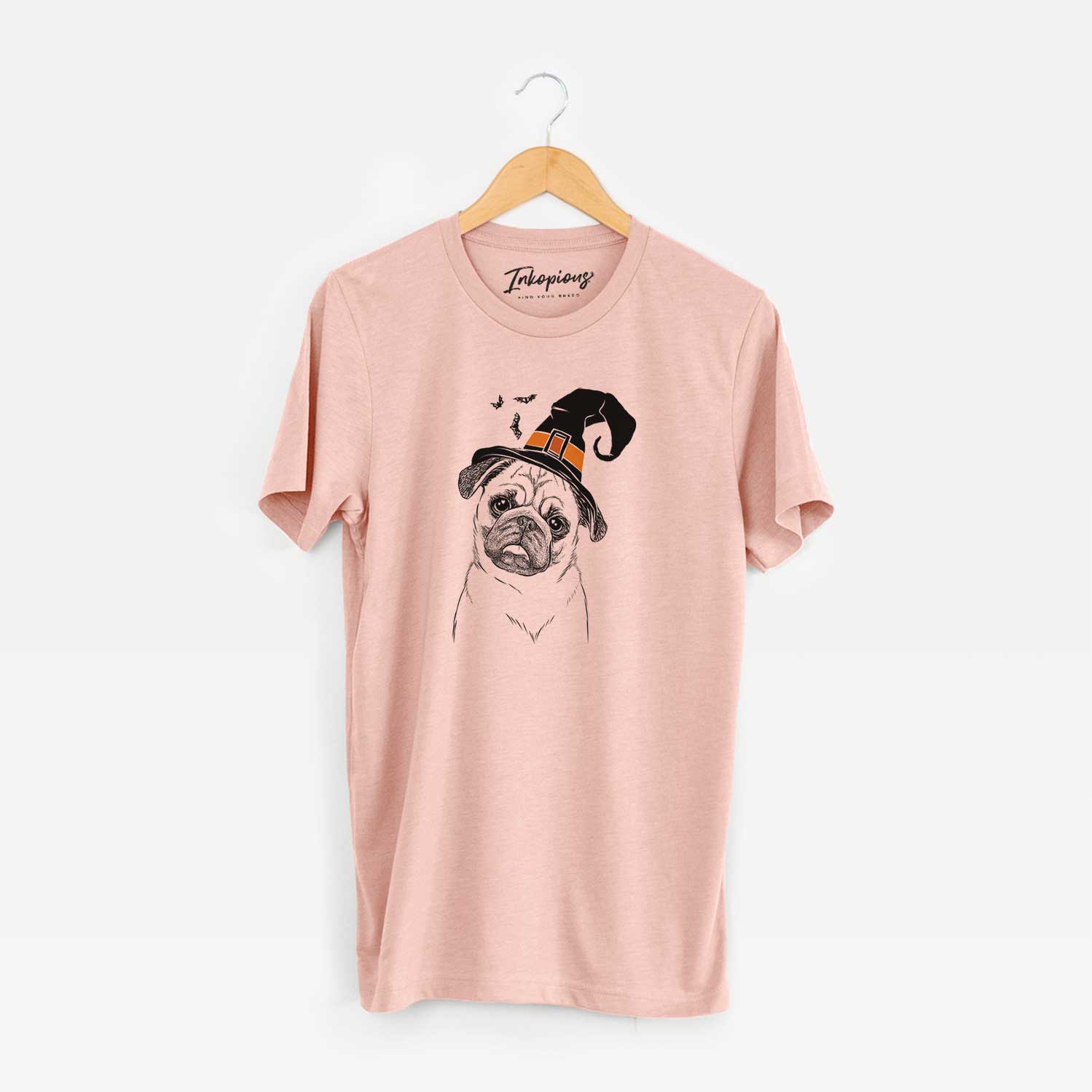 Hand-drawn sketch of Macy the Pug wearing a witch hat on a Peach Unisex crewneck