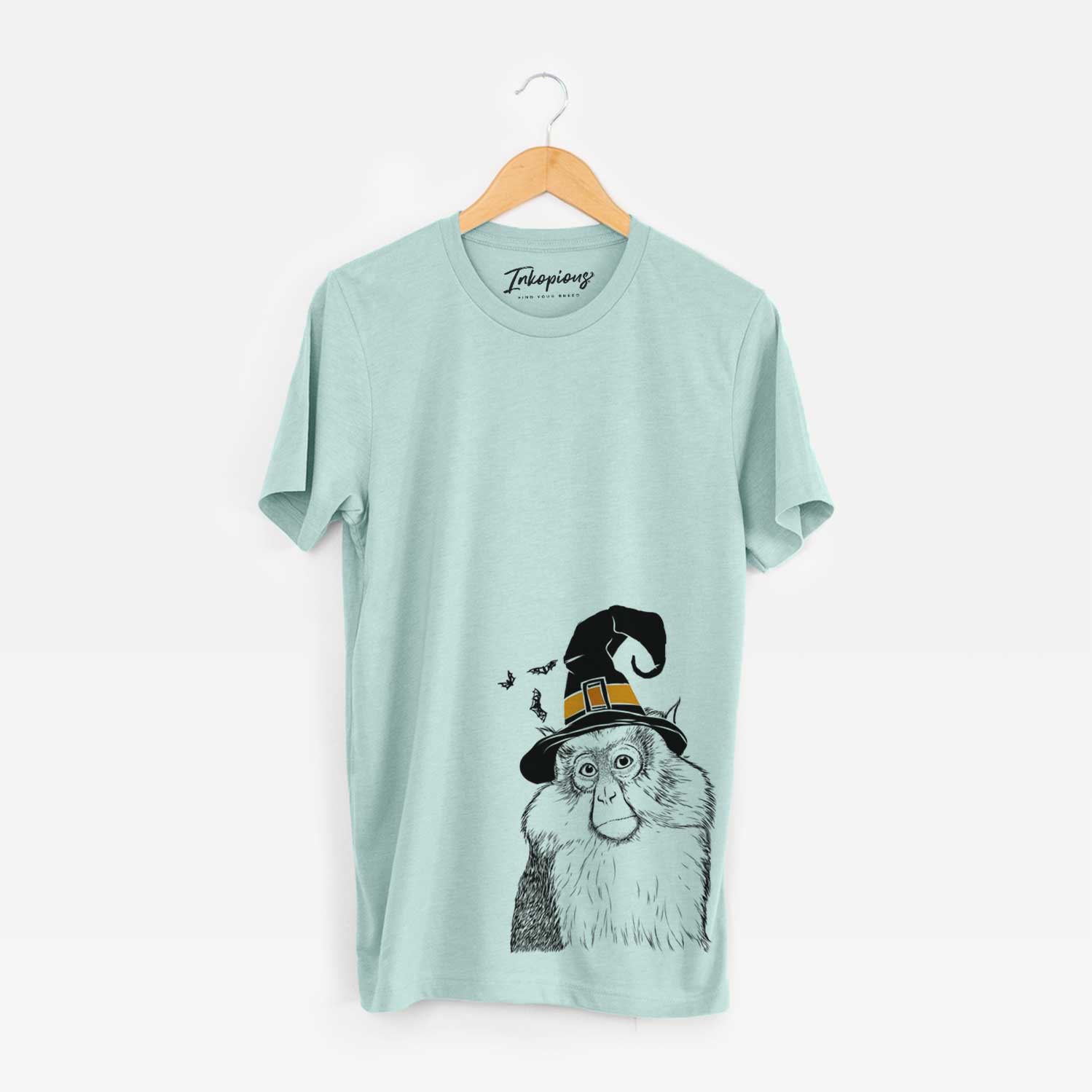Hand-drawn sketch of Matata the Mona Monkey wearing a witch hat on a Heather Sage Unisex crewneck