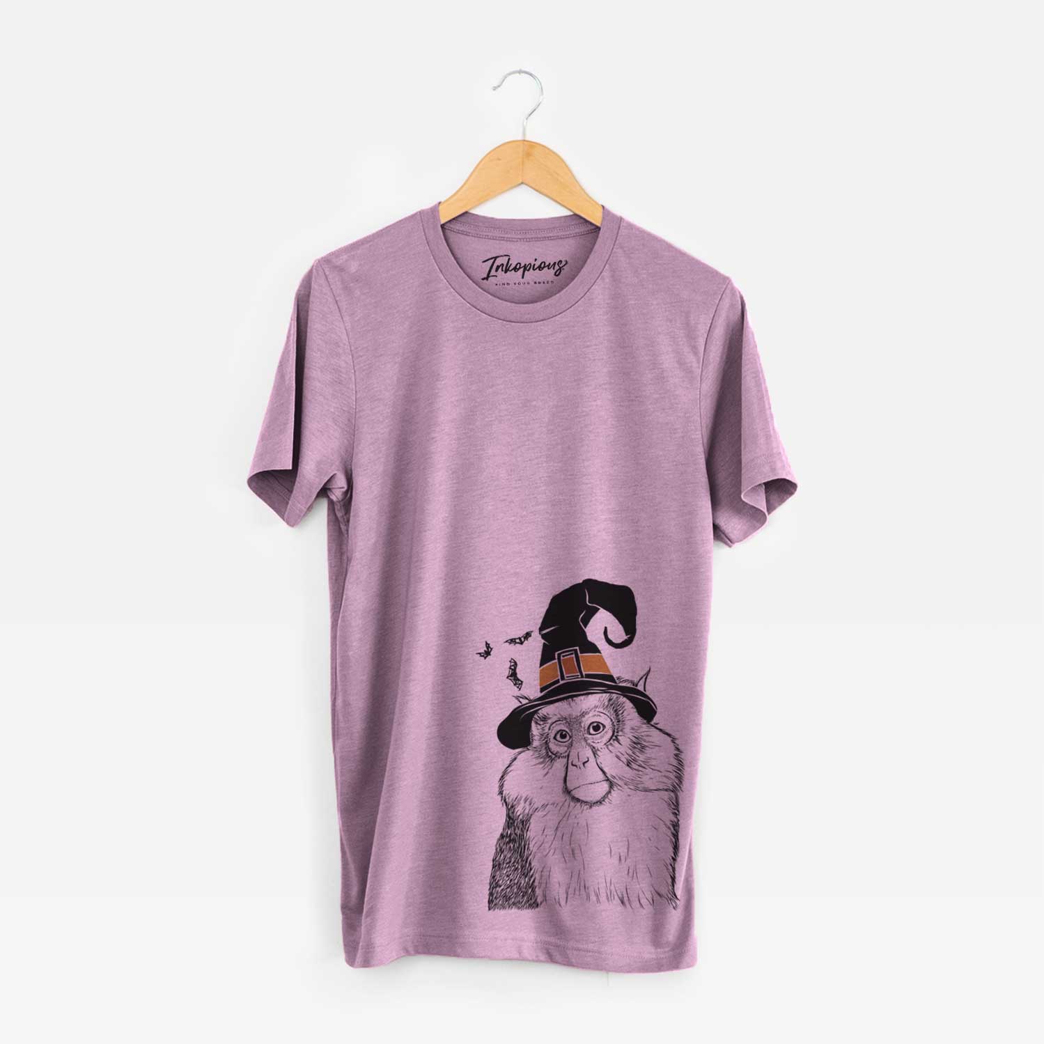 Hand-drawn sketch of Matata the Mona Monkey wearing a witch hat on an Orchid Unisex crewneck