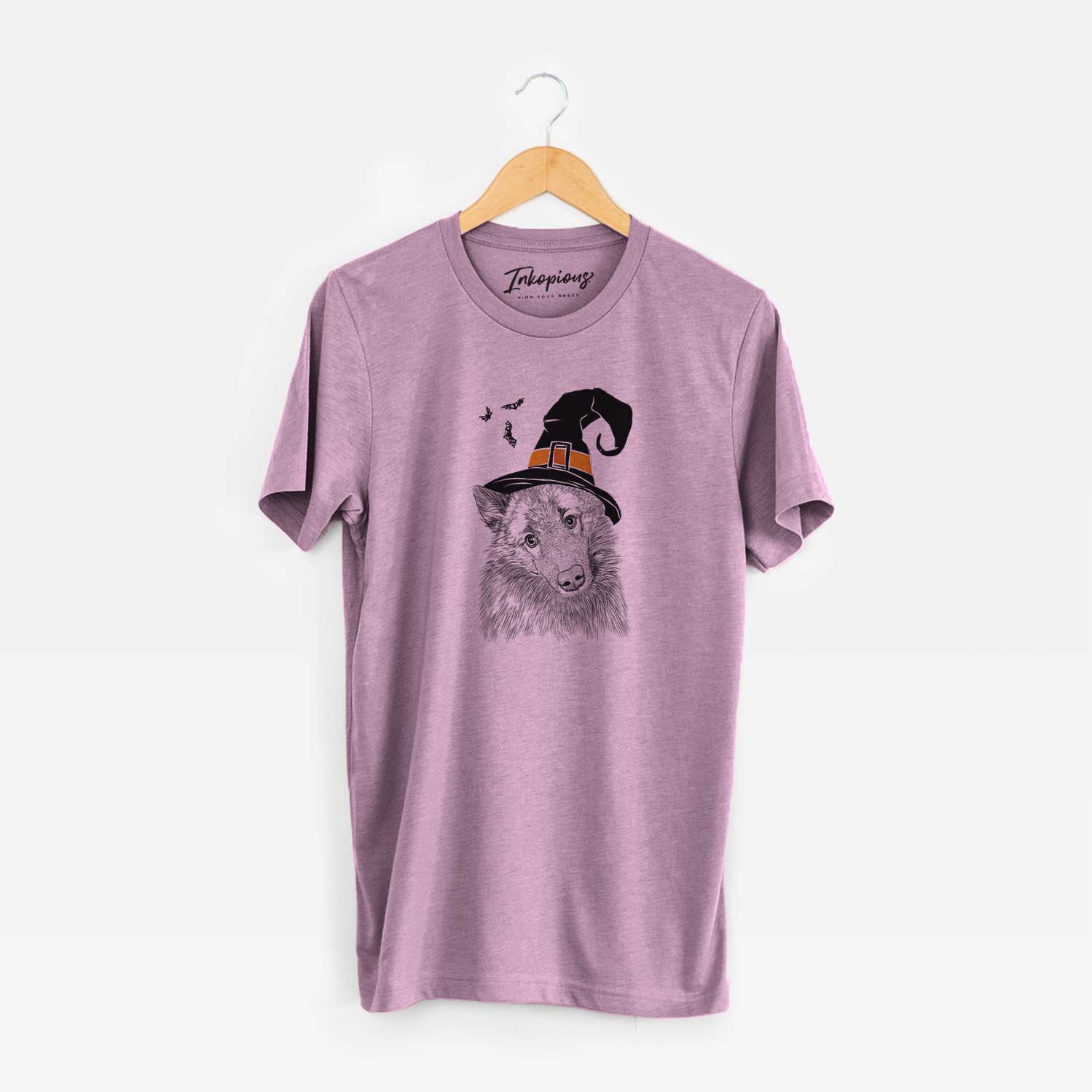 Hand-drawn sketch of Mr. Maverick the Keeshond wearing a witch hat on an Orchid Unisex crewneck