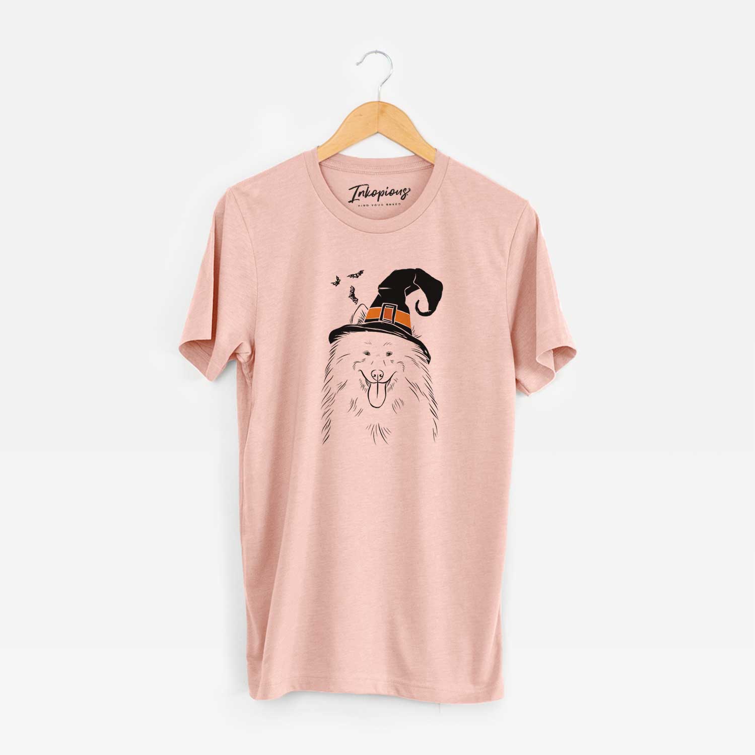 Hand-drawn sketch of Nova the Samoyed wearing a witch hat on a Peach Unisex crewneck