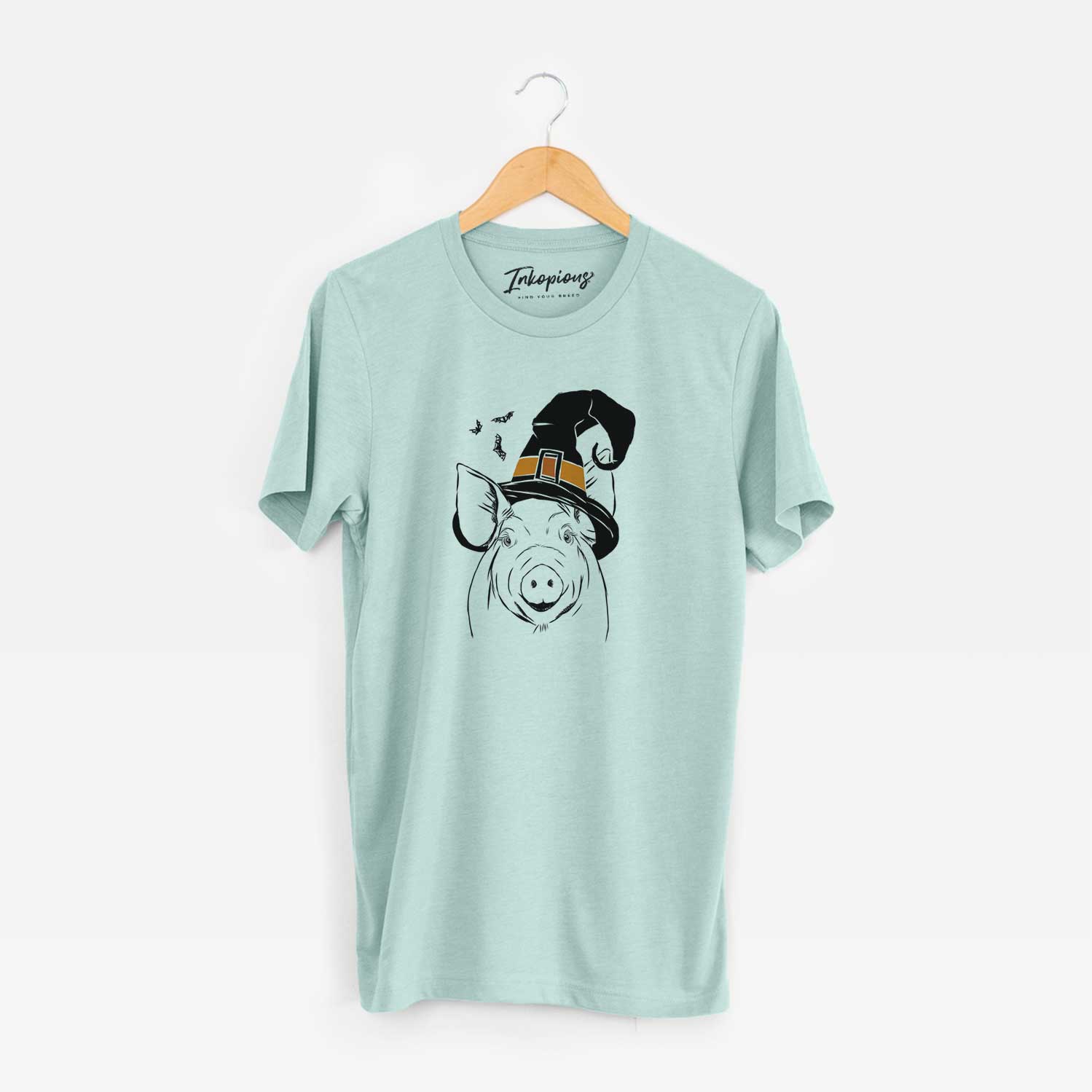 Hand-drawn sketch of Perry the Pig wearing a witch hat on a Heather Sage Unisex crewneck