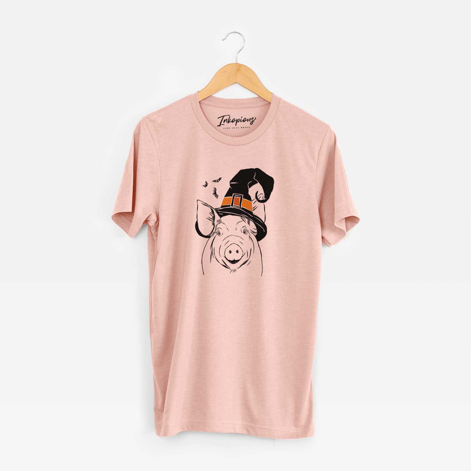 Hand-drawn sketch of Perry the Pig wearing a witch hat on a Peach Unisex crewneck
