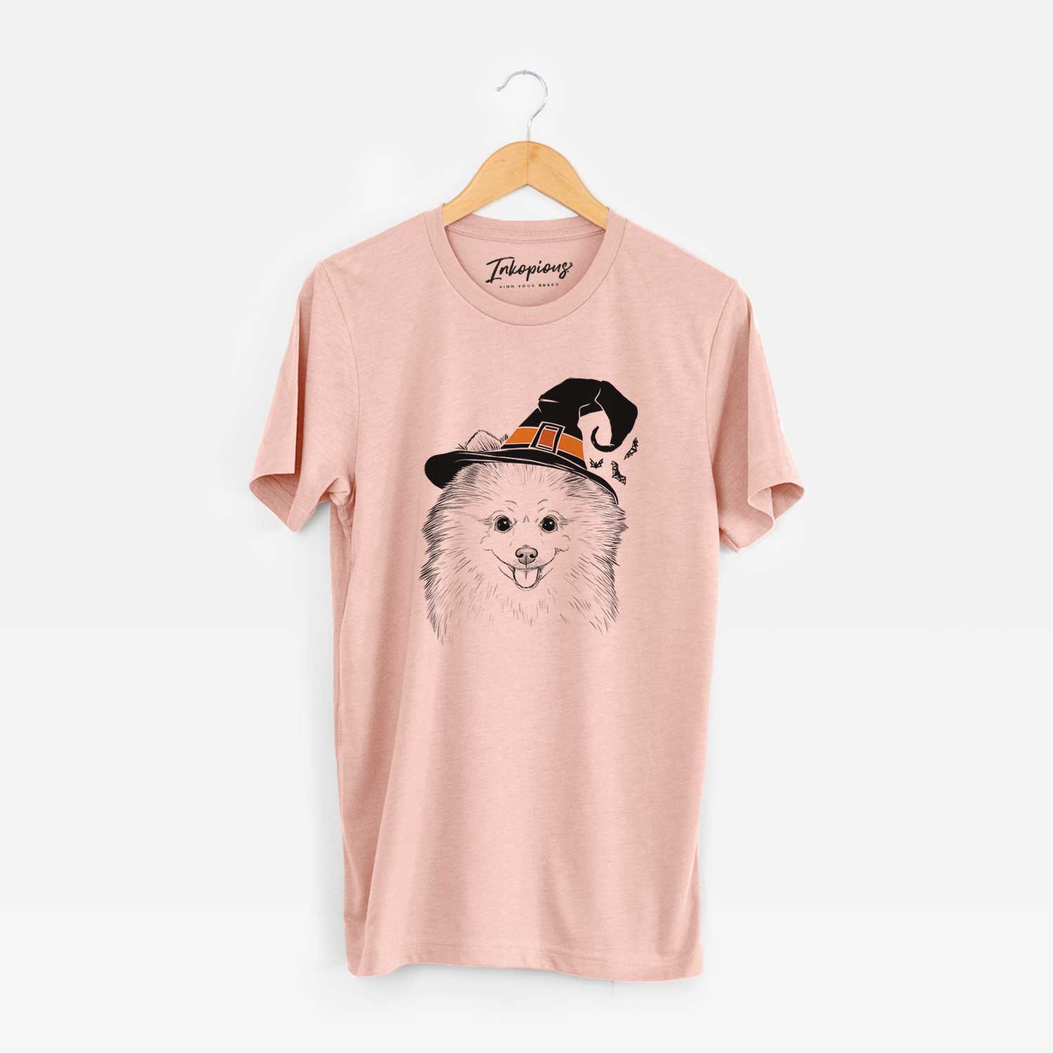 Hand-drawn sketch of Piper Jo the Pomeranian wearing a witch hat on a Peach Unisex crewneck