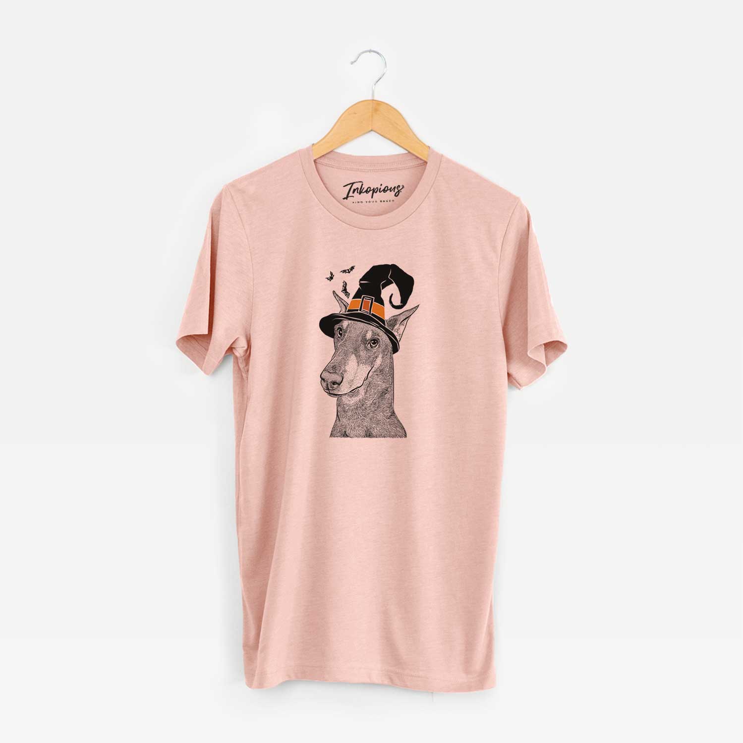 Hand-drawn sketch of Shelby the Doberman Pinscher wearing a witch hat on a Peach Unisex crewneck