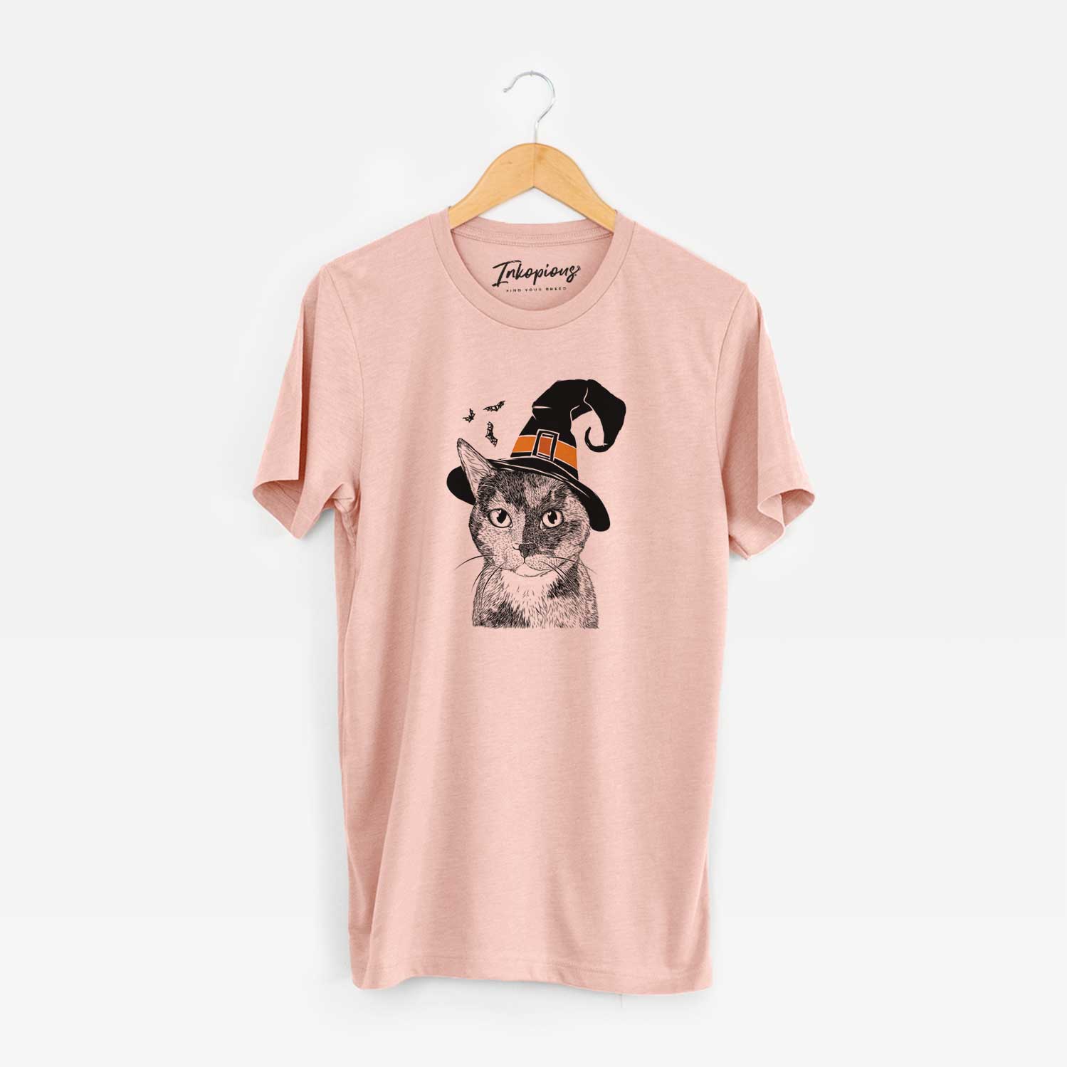 Hand-drawn sketch of Spooky Kitty the Tortoiseshell Cat wearing a witch hat on a Peach Unisex crewneck