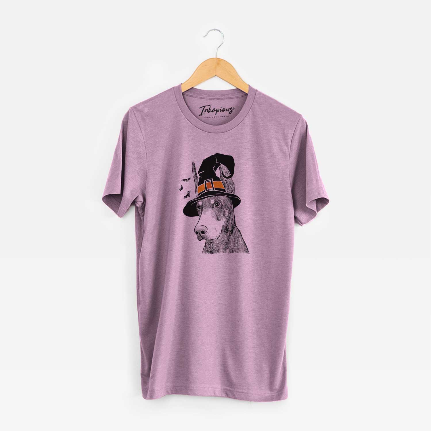 Hand-drawn sketch of Sunny the Doberman Pinscher wearing a witch hat on an Orchid Unisex crewneck