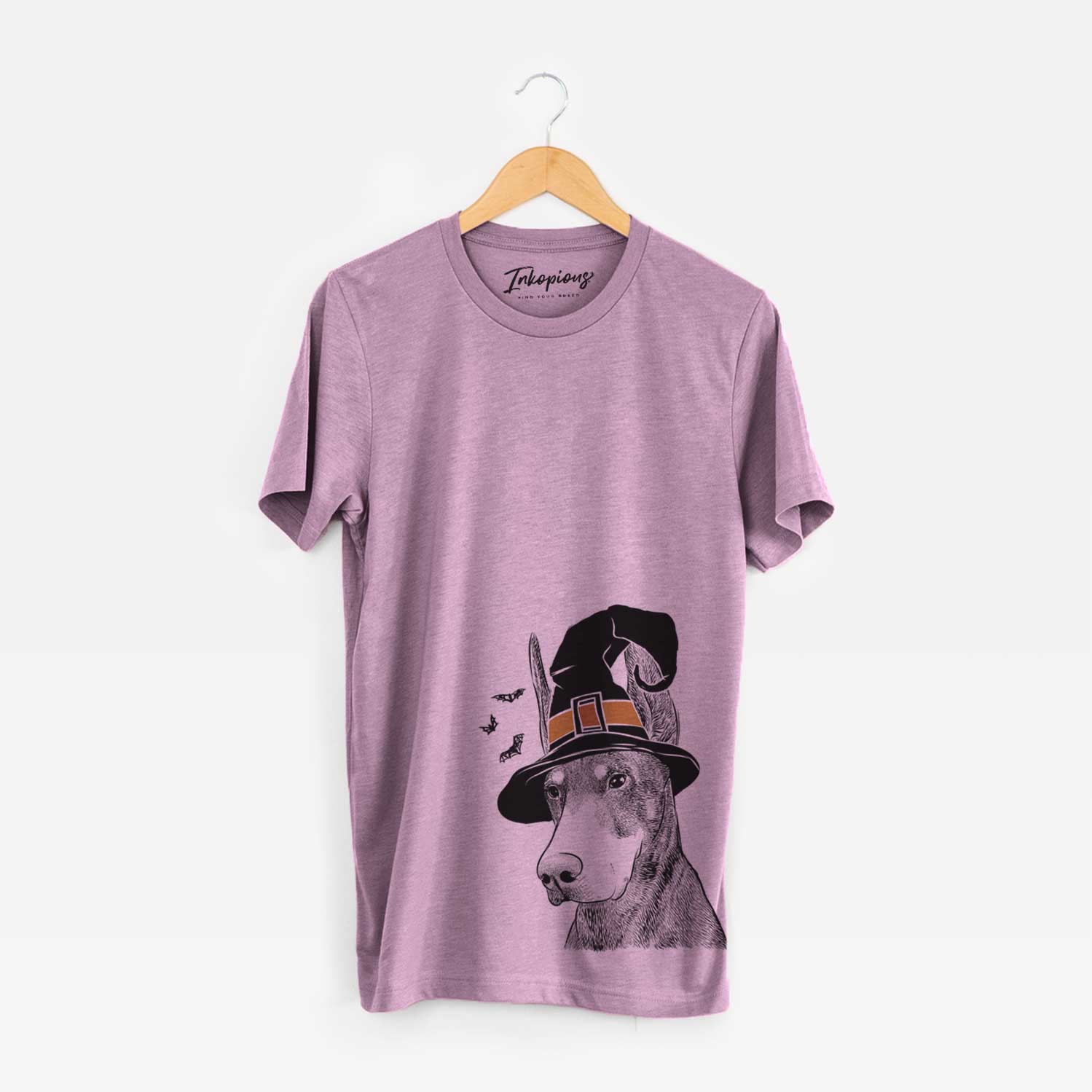 Hand-drawn sketch of Sunny the Doberman Pinscher wearing a witch hat on an Orchid Unisex crewneck