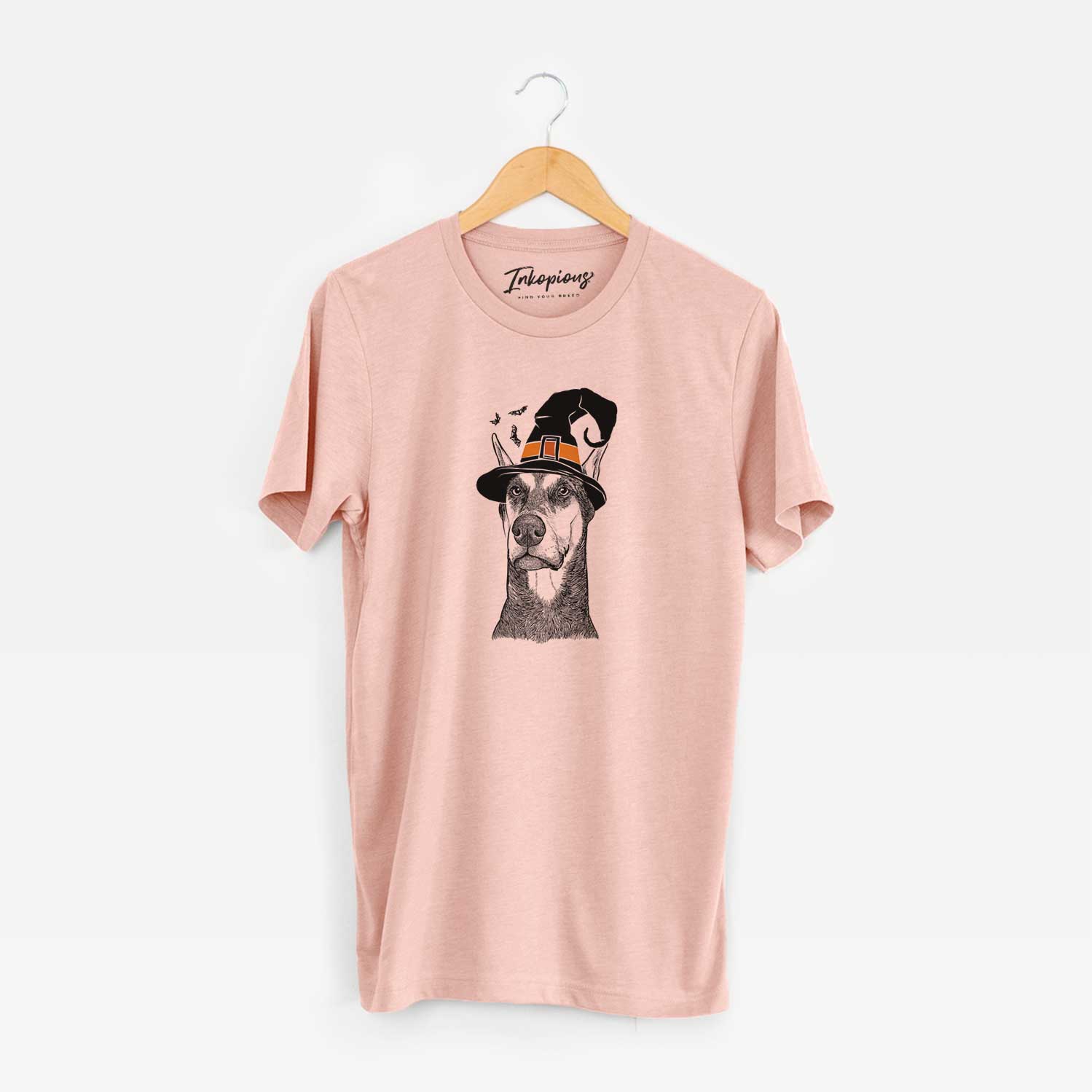 Hand-drawn sketch of Zeus the Doberman Pinscher wearing a witch hat on a Peach Unisex crewneck