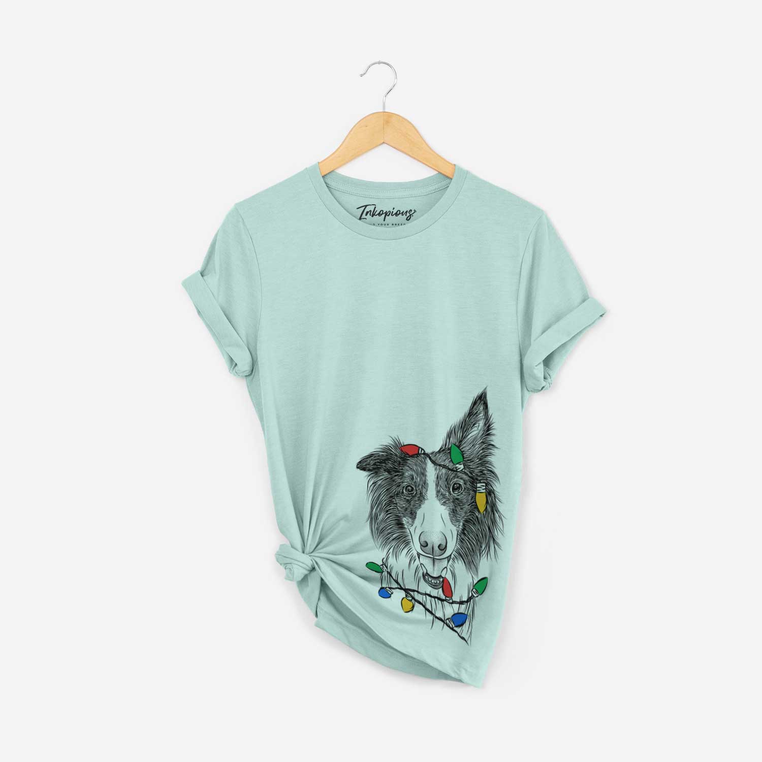 Hand-drawn sketch of Archie the Silken Windhound wrapped in Christmas lights on a Heather Sage Unisex crewneck