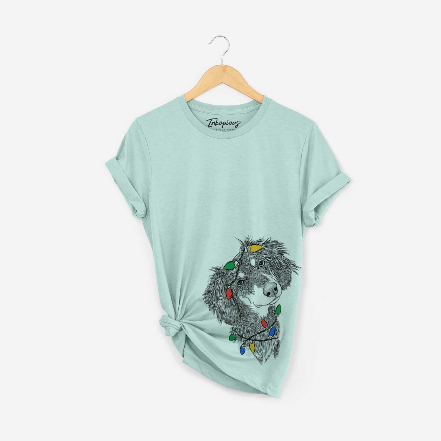 Hand-drawn sketch of Bailey the Long Haired Dachshund wrapped in Christmas lights on a Heather Sage Unisex crewneck