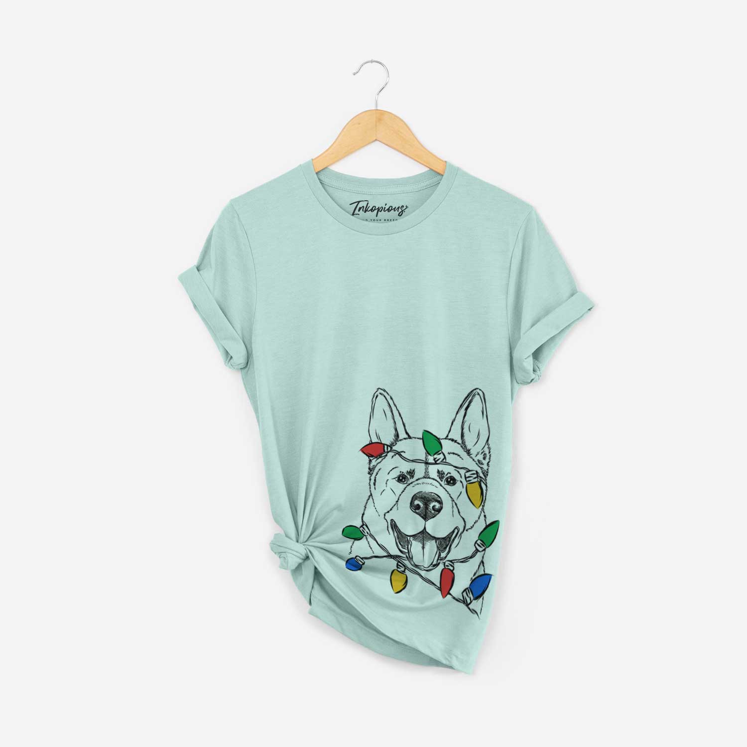 Hand-drawn sketch of Baku the Akita wrapped in Christmas lights on a Heather Sage Unisex crewneck