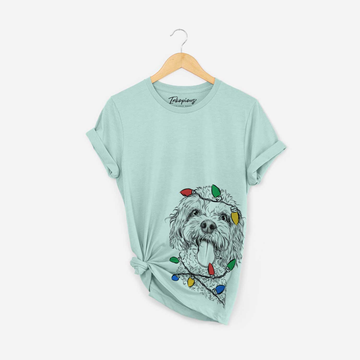 Hand-drawn sketch of Barney the Cavachon wrapped in Christmas lights on a Heather Sage Unisex crewneck