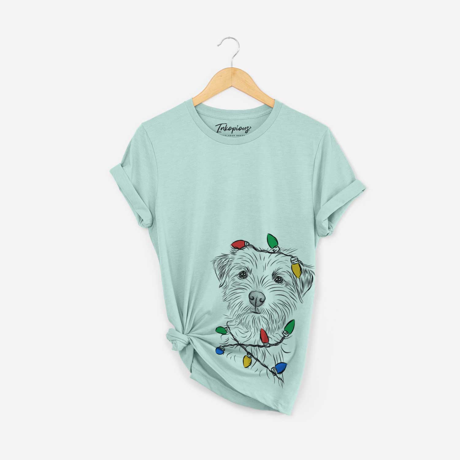 Hand-drawn sketch of Benjamin the Border Terrier wrapped in Christmas lights on a Heather Sage Unisex crewneck