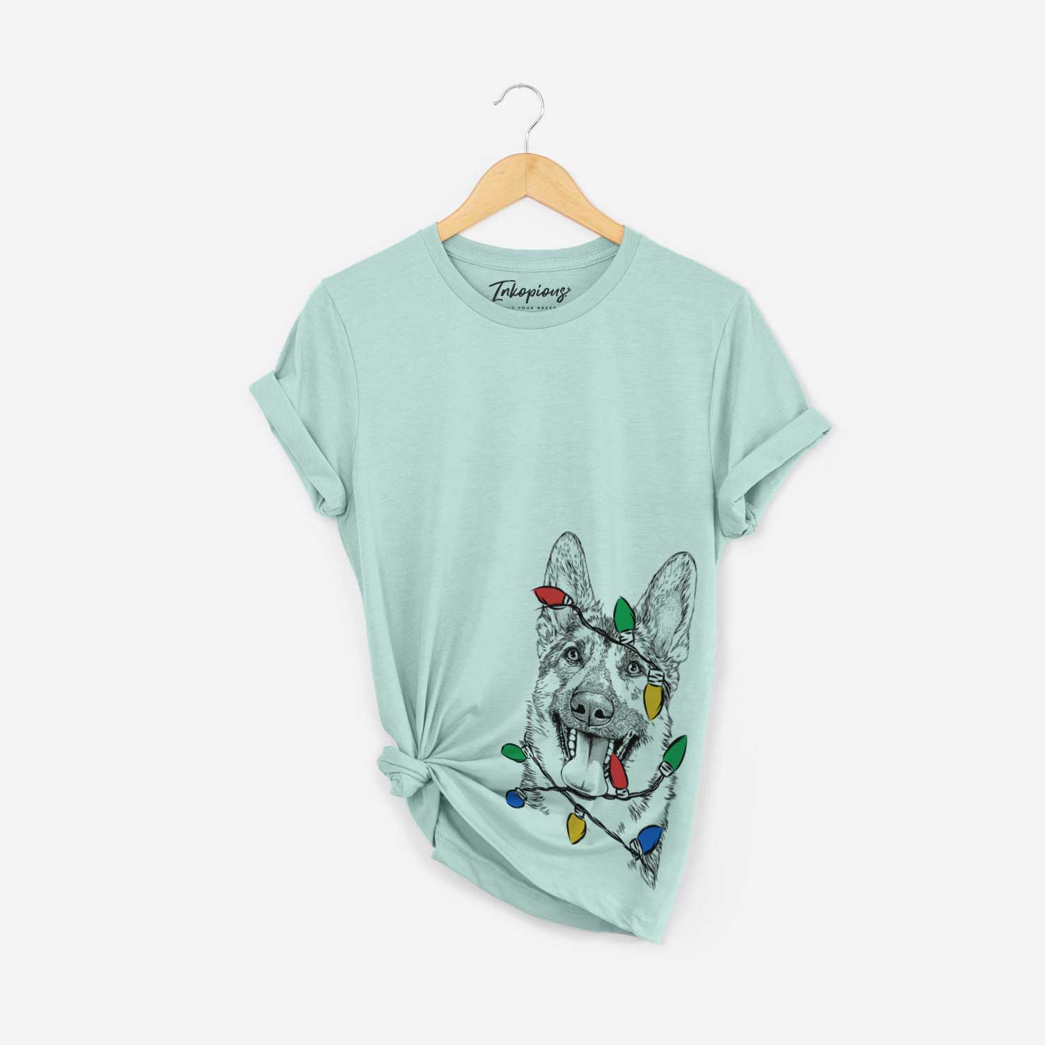Hand-drawn sketch of Benson the German Shepherd wrapped in Christmas lights on a Heather Sage Unisex crewneck