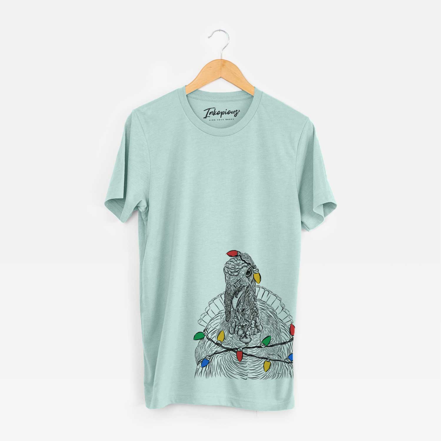 Hand-drawn sketch of Brady the Turkey wrapped in Christmas lights on a Heather Sage Unisex crewneck