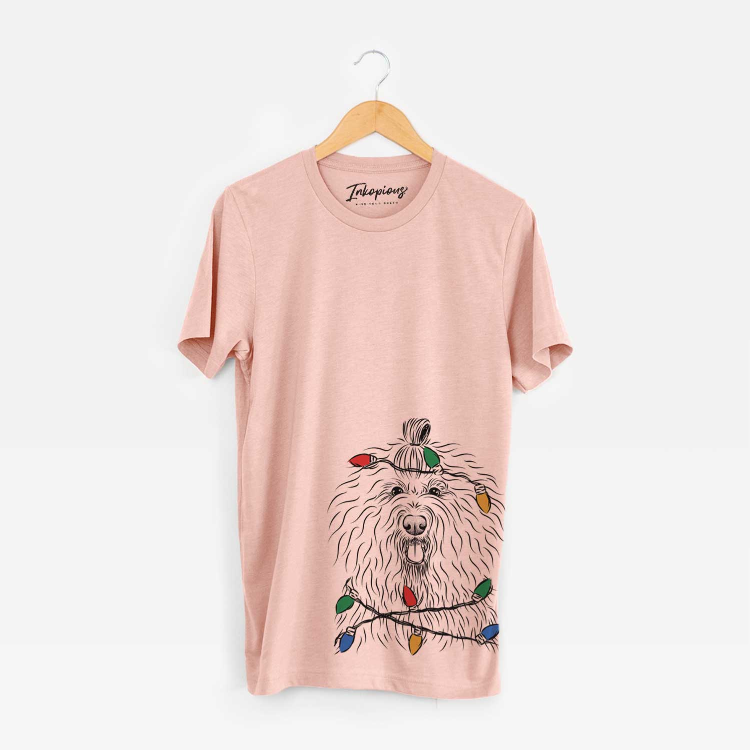 Hand-drawn sketch of Brody the Old English Sheepdog wrapped in Christmas lights on a Peach Unisex crewneck