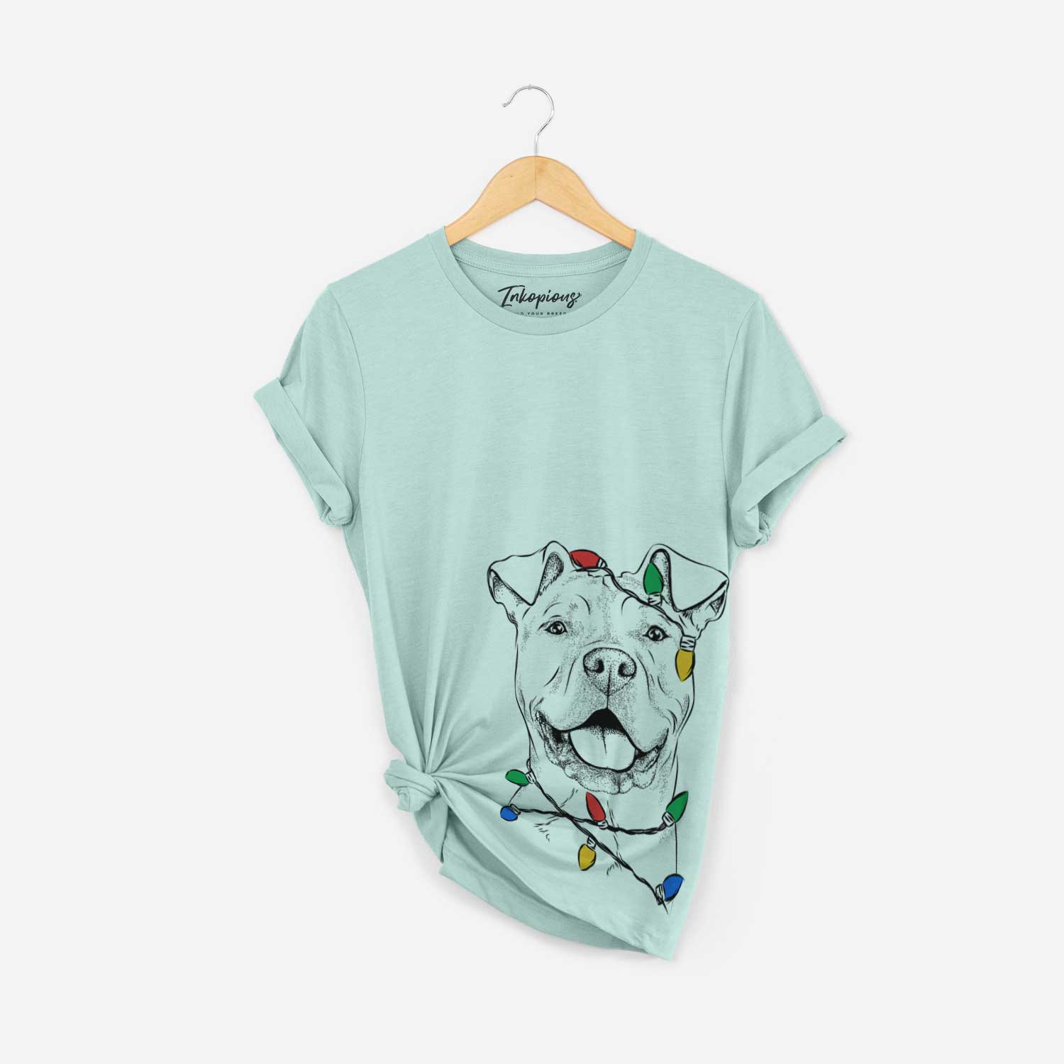 Hand-drawn sketch of Bubba Scraps the American Staffordshire Mix wrapped in Christmas lights on a Heather Sage Unisex crewneck