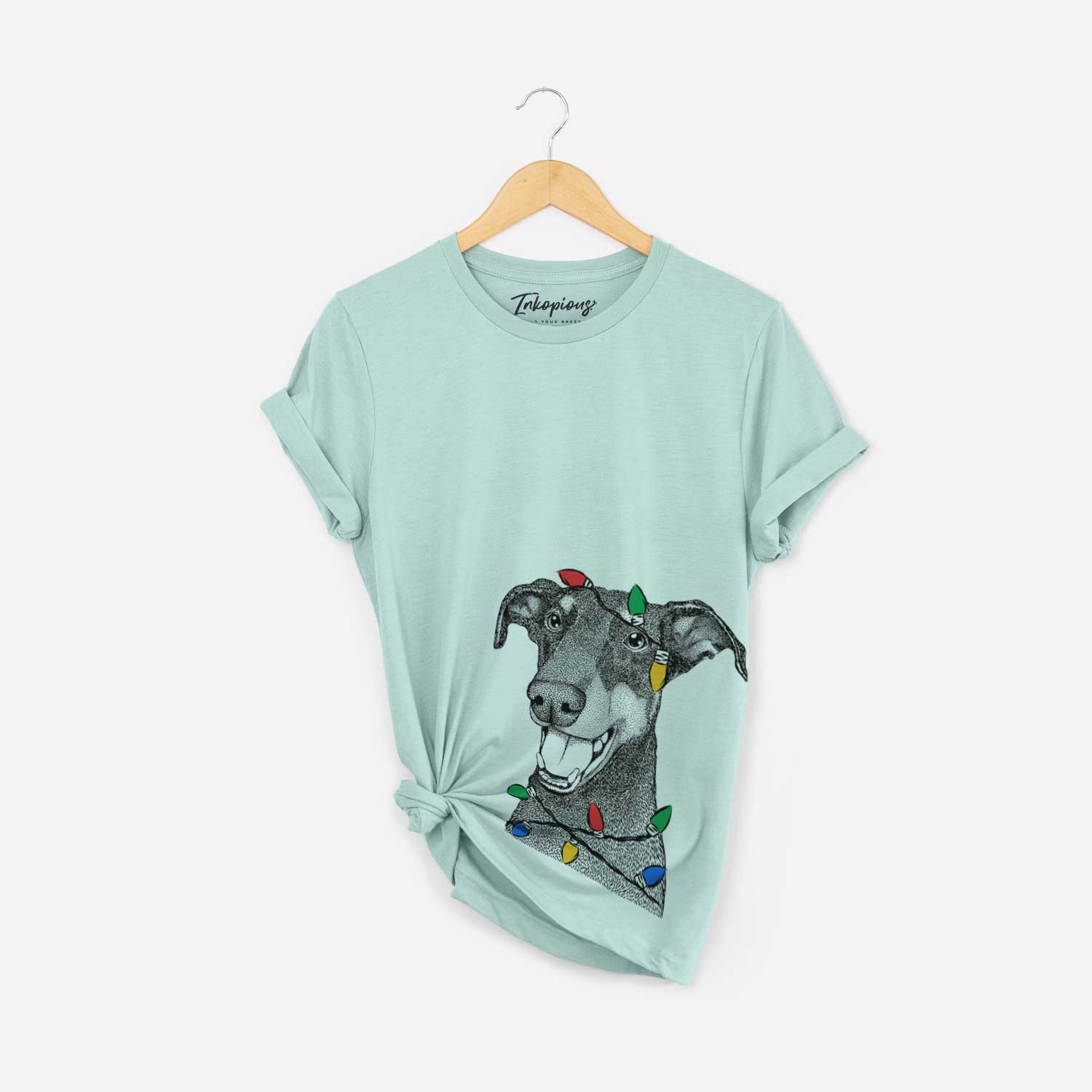 Hand-drawn sketch of Bunnie the Doberman Pinscher wrapped in Christmas lights on a Heather Sage Unisex crewneck