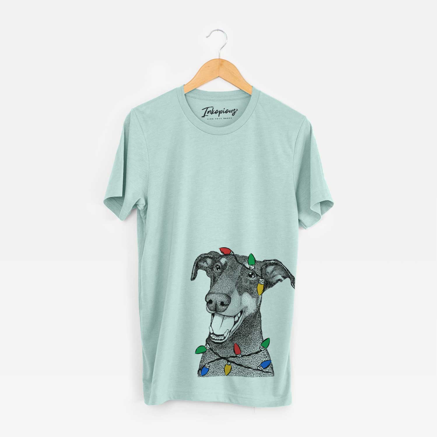 Hand-drawn sketch of Bunnie the Doberman Pinscher wrapped in Christmas lights on a Heather Sage Unisex crewneck