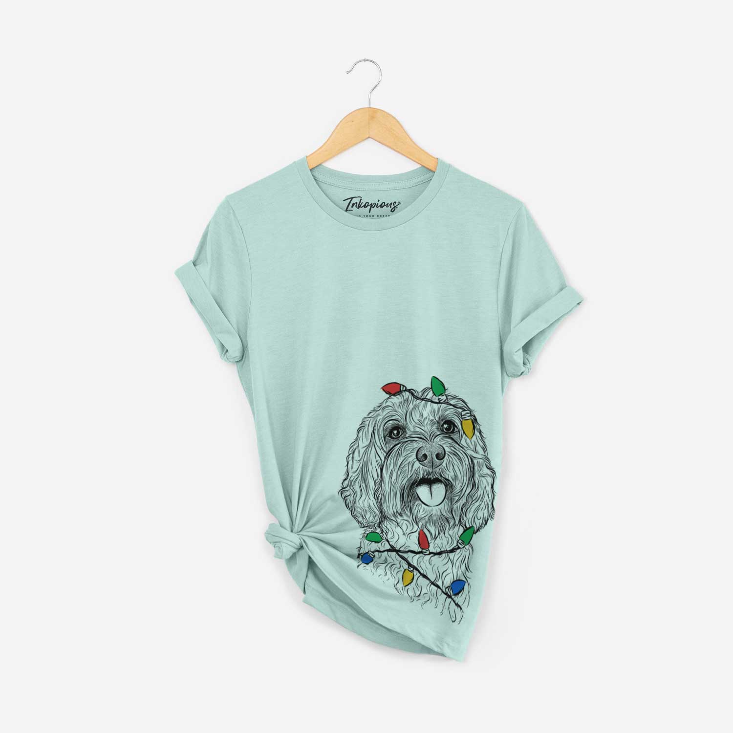 Hand-drawn sketch of Cali the Cavapoo wrapped in Christmas lights on a Heather Sage Unisex crewneck