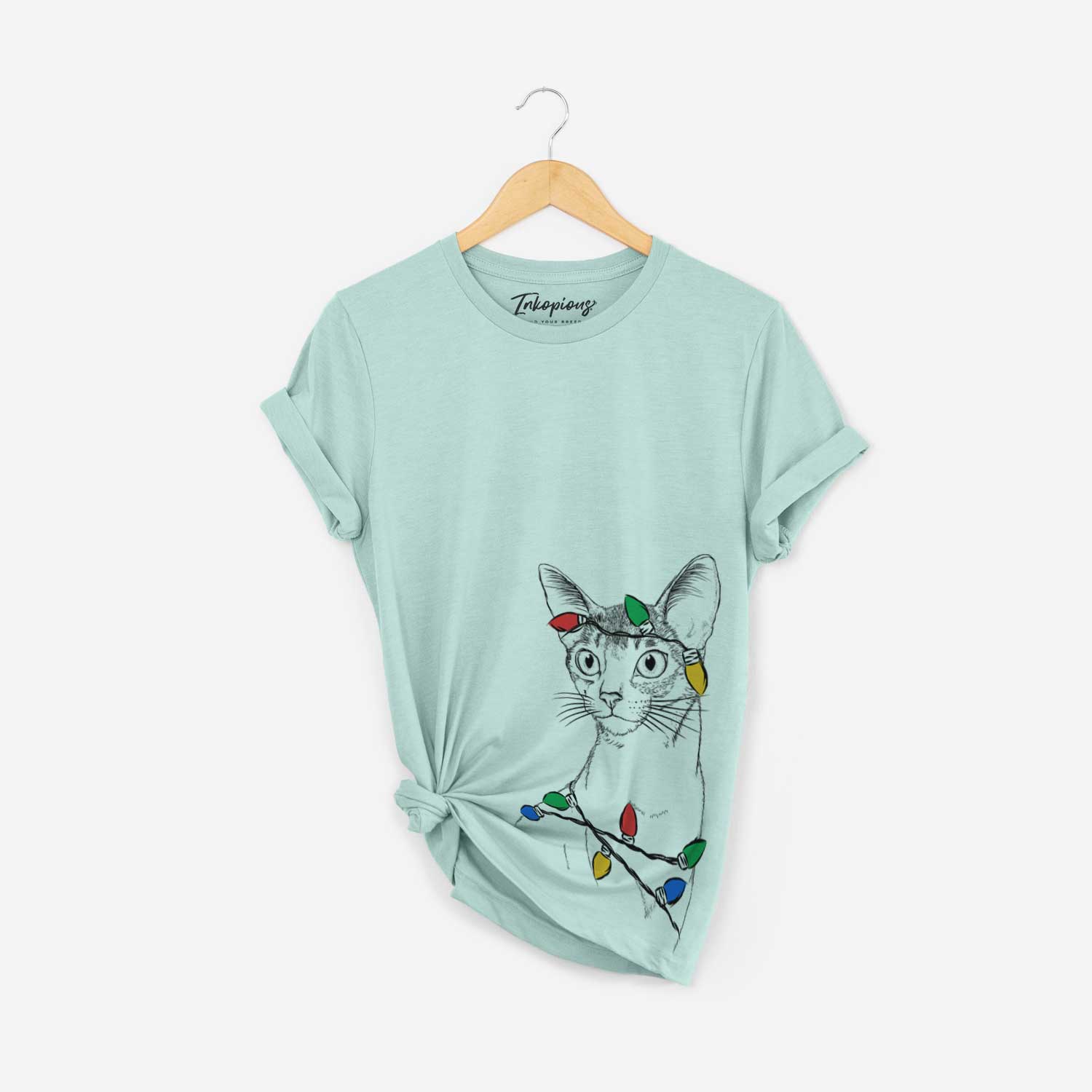 Hand-drawn sketch of Cedric the Abyssinian Cat wrapped in Christmas lights on a Heather Sage Unisex crewneck