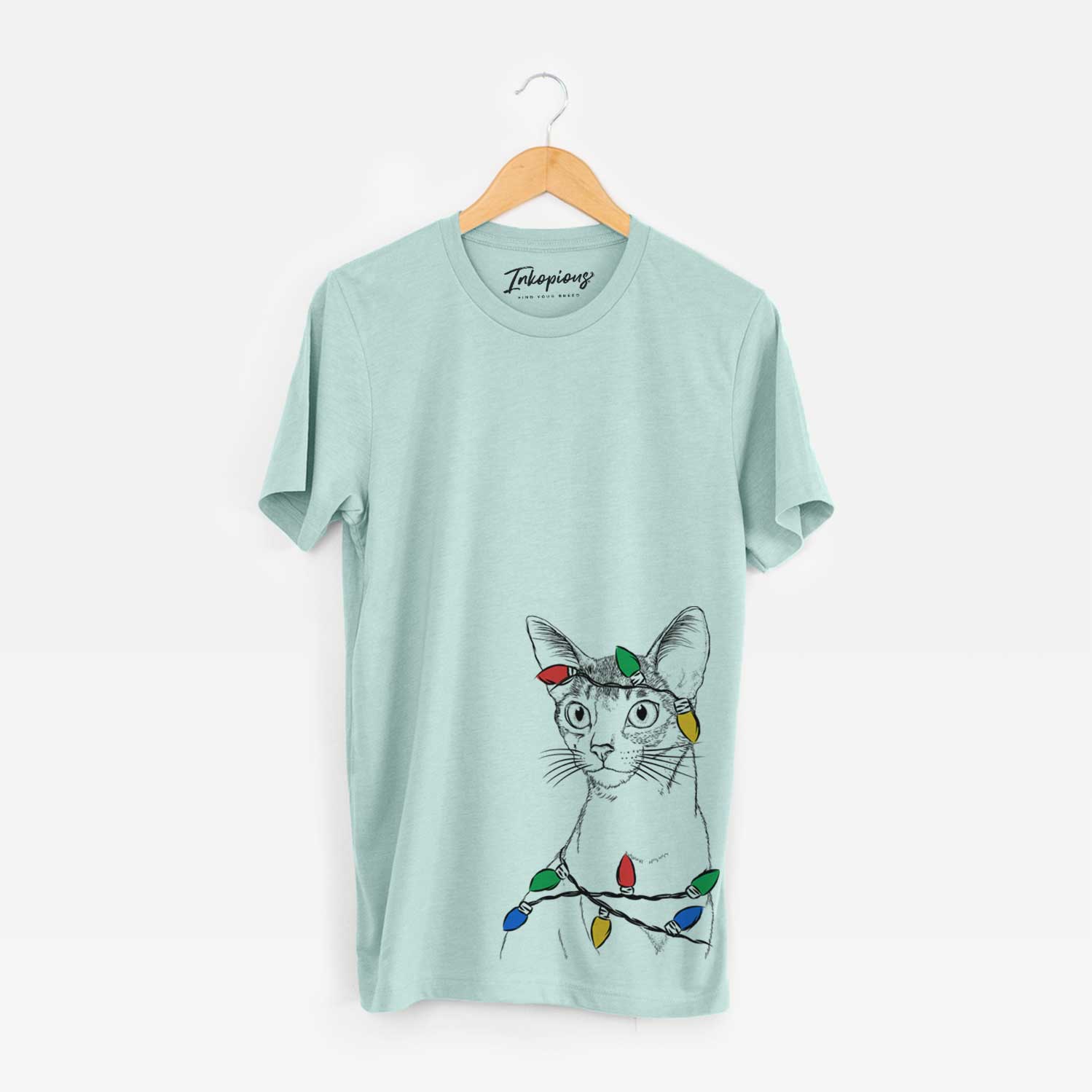 Hand-drawn sketch of Cedric the Abyssinian Cat wrapped in Christmas lights on a Heather Sage Unisex crewneck