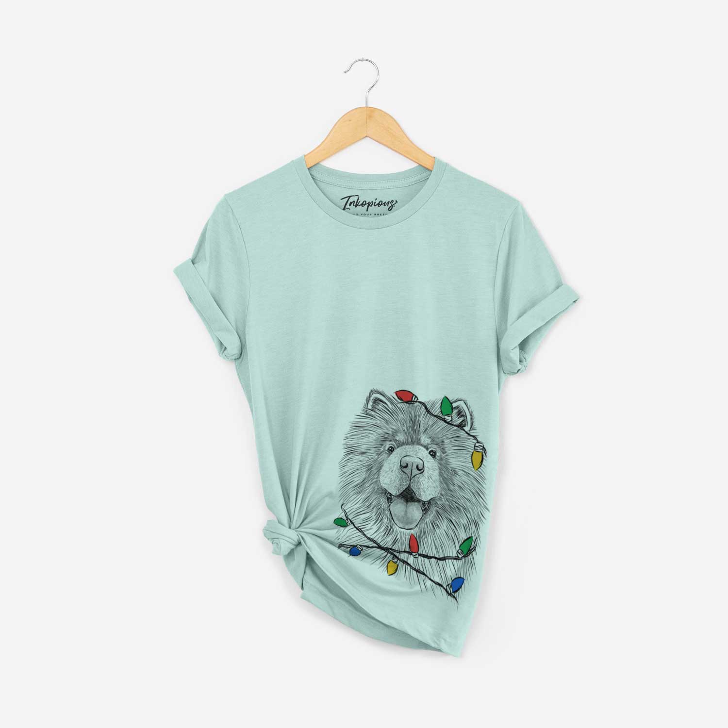 Hand-drawn sketch of Charming Charlie the Chow Chow wrapped in Christmas lights on a Heather Sage Unisex crewneck