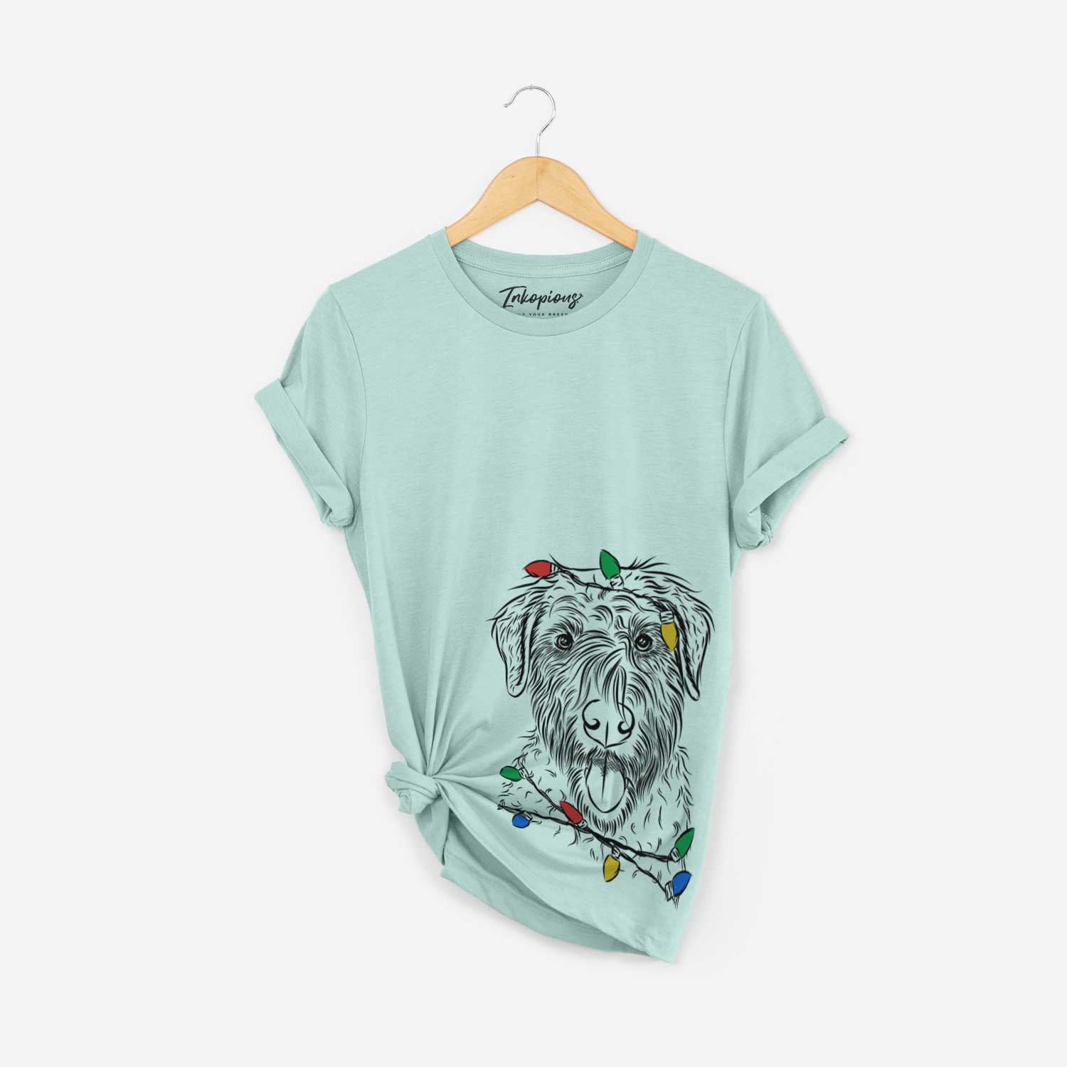 Hand-drawn sketch of Chester the Soft Coated Wheaten Terrier wrapped in Christmas lights on a Heather Sage Unisex crewneck