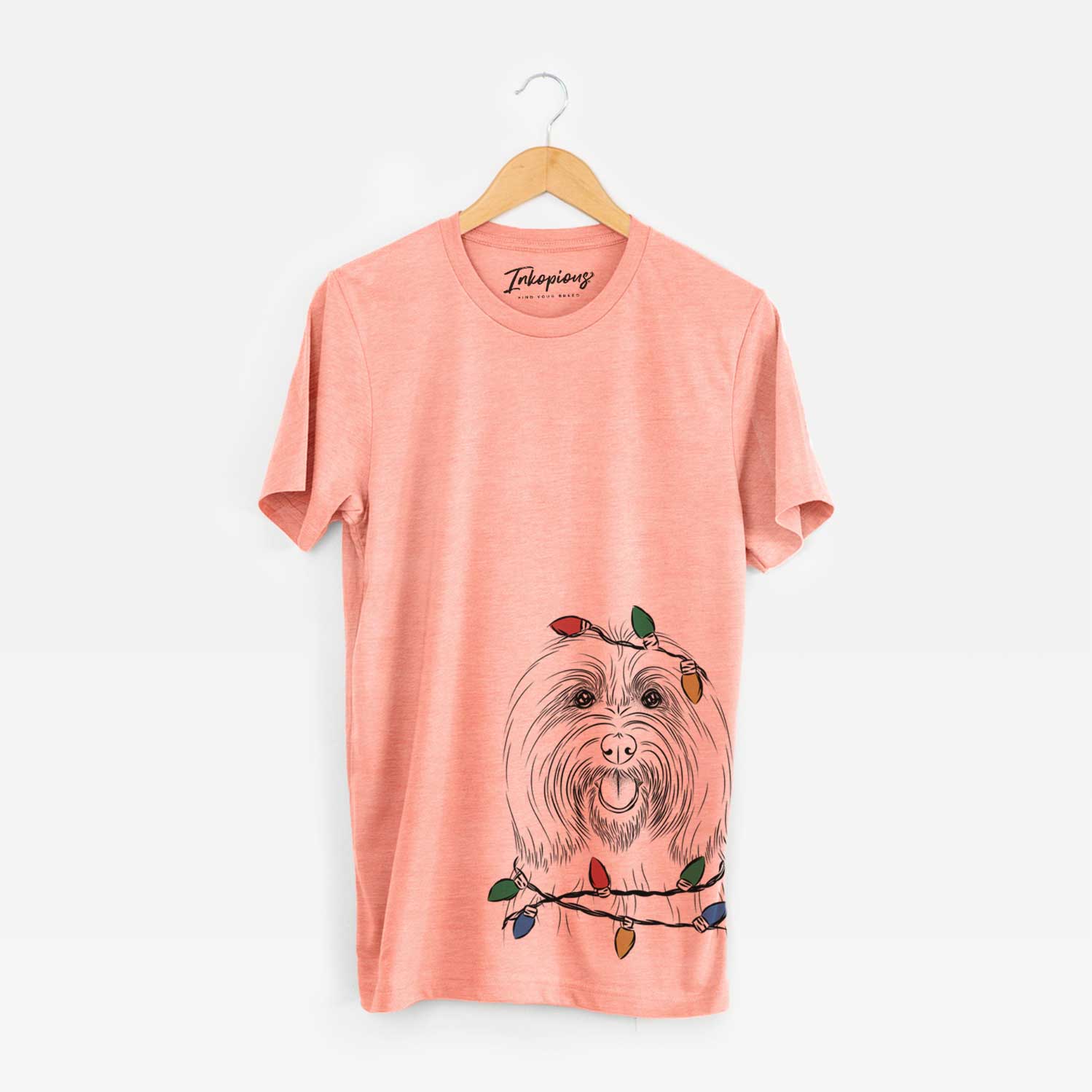 Hand-drawn sketch of Claude the Coton de Tulear wrapped in Christmas lights on a Sunset Unisex crewneck