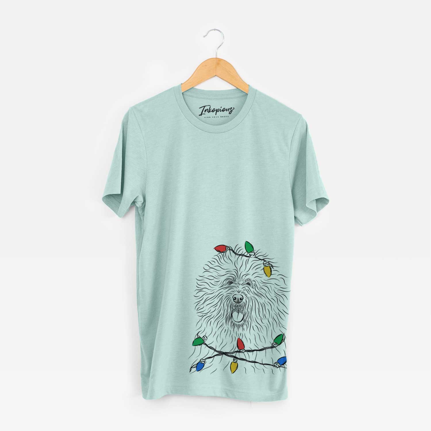 Hand-drawn sketch of Cozie the Old English Sheepdog wrapped in Christmas lights on a Heather Sage Unisex crewneck