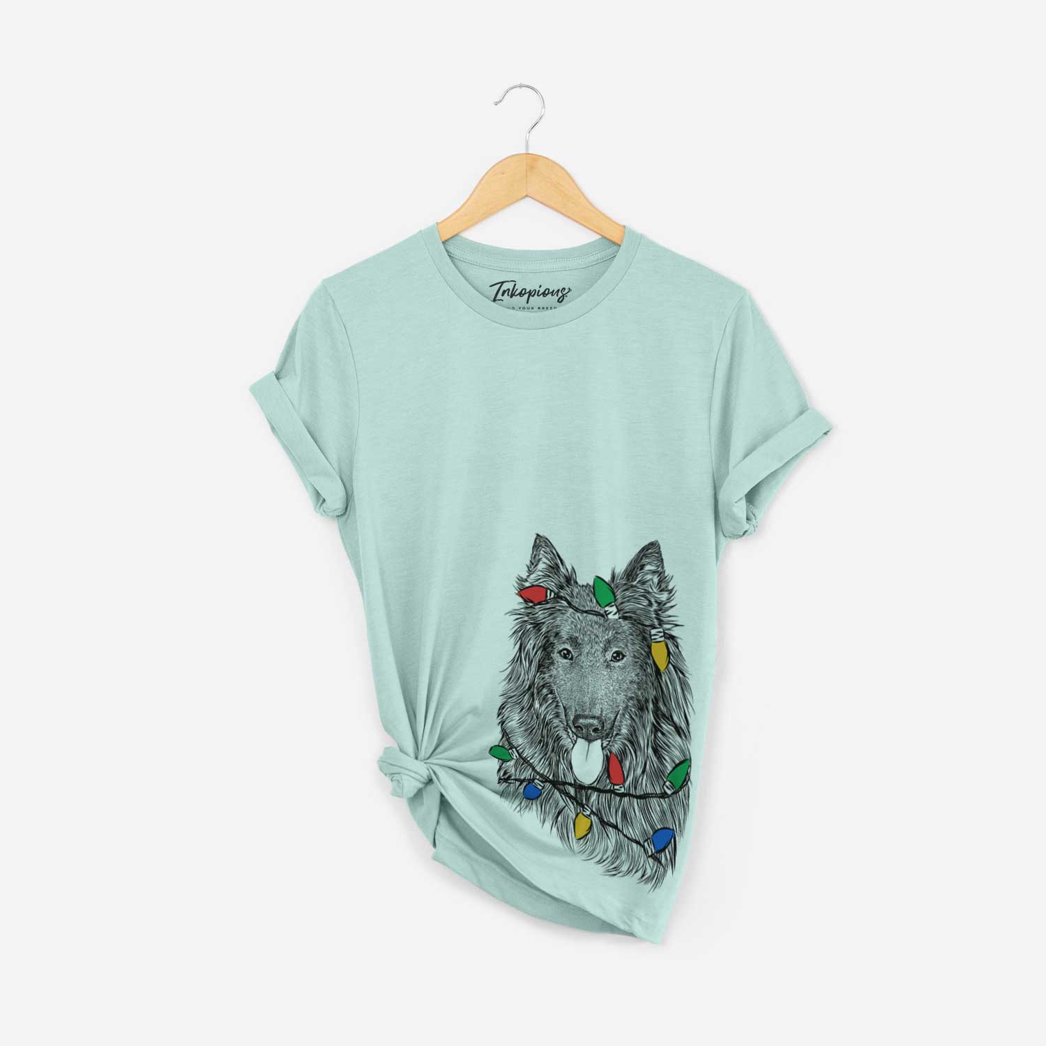 Hand-drawn sketch of Daan the Belgian Shepherd wrapped in Christmas lights on a Heather Sage Unisex crewneck