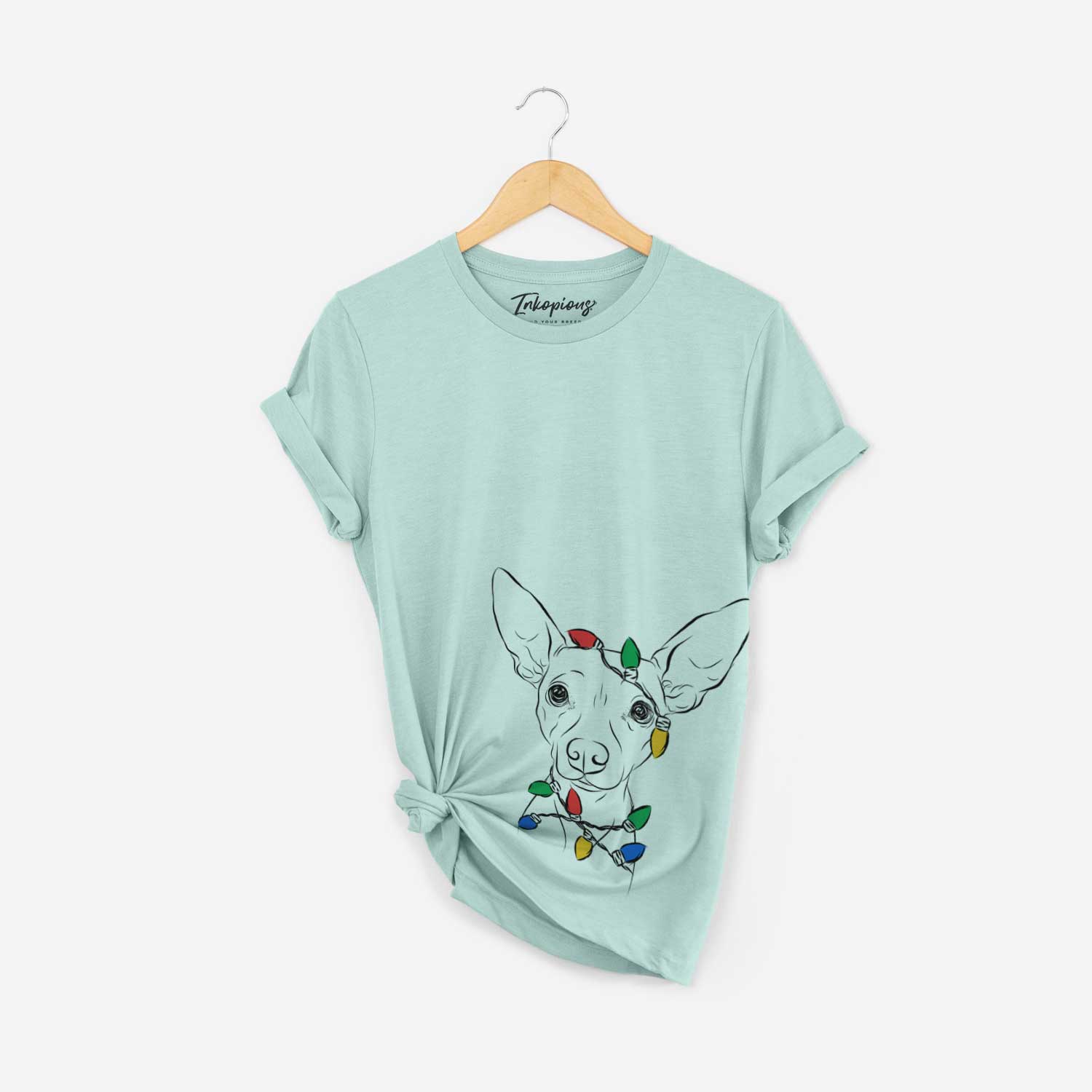 Hand-drawn sketch of Desi the American Hairless Terrier wrapped in Christmas lights on a Heather Sage Unisex crewneck