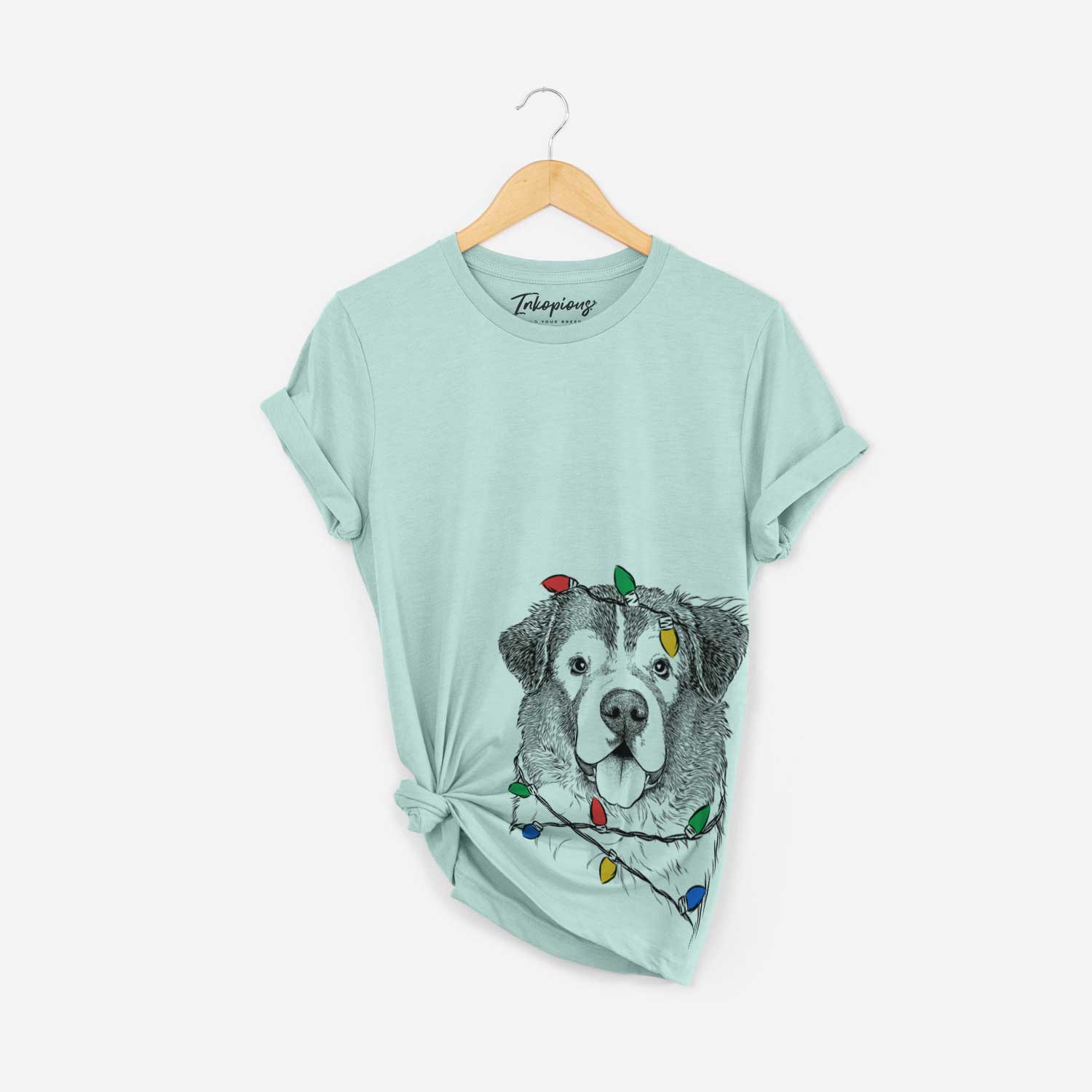 Hand-drawn sketch of Dilly the Saint Bernard wrapped in Christmas lights on a Heather Sage Unisex crewneck