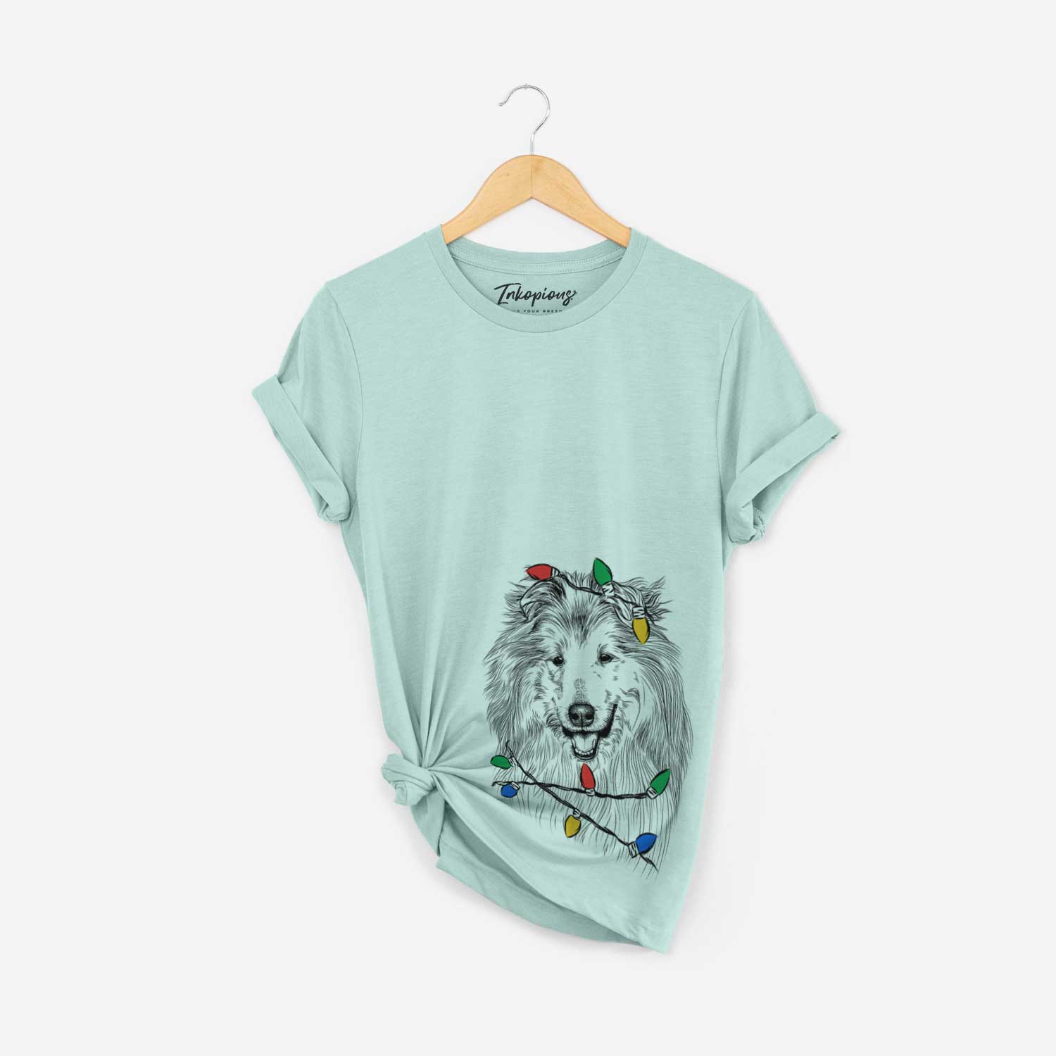 Hand-drawn sketch of Donnan the Rough Collie wrapped in Christmas lights on a Heather Sage Unisex crewneck