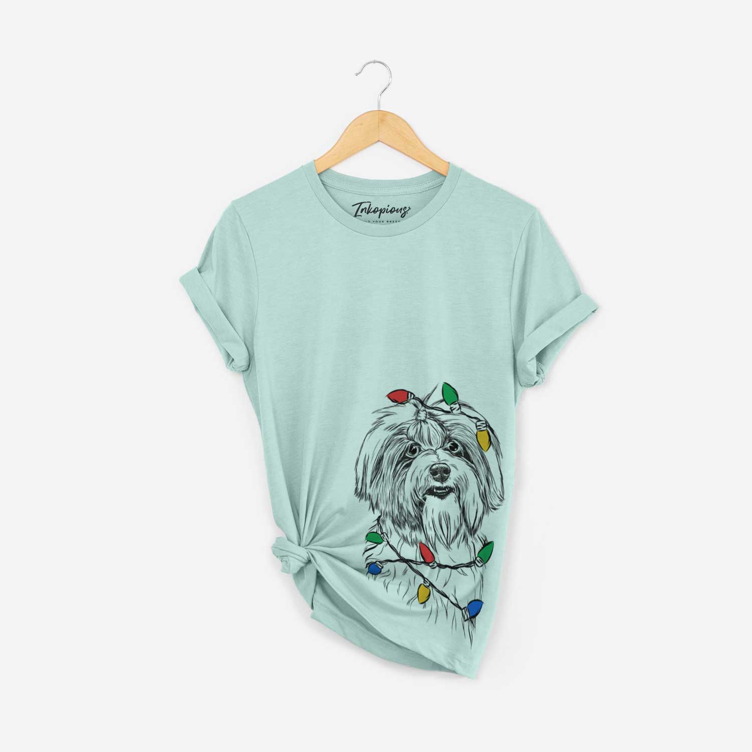 Hand-drawn sketch of Dooley the Havanese wrapped in Christmas lights on a Heather Sage Unisex crewneck