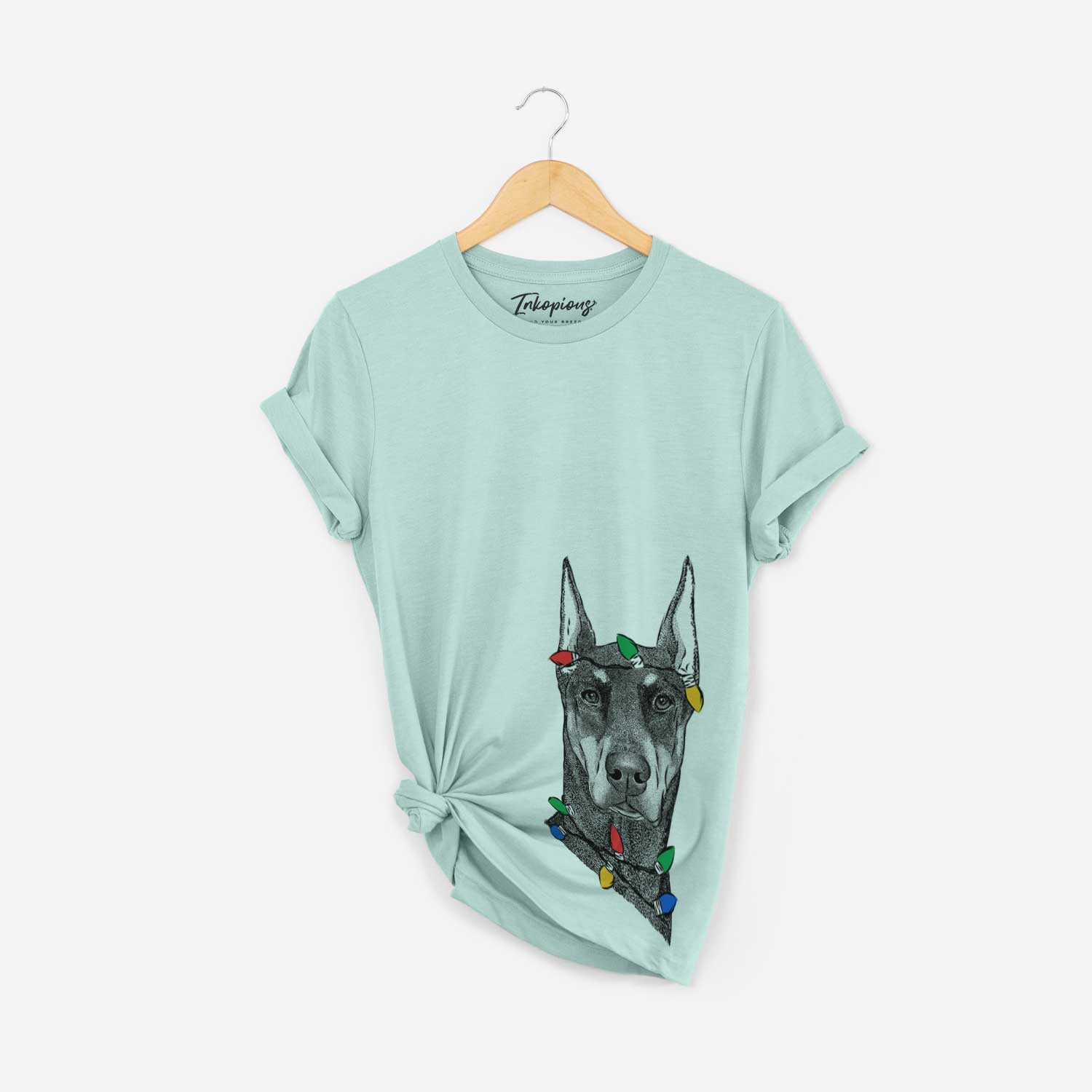 Hand-drawn sketch of Drake the Doberman Pinscher wrapped in Christmas lights on a Heather Sage Unisex crewneck